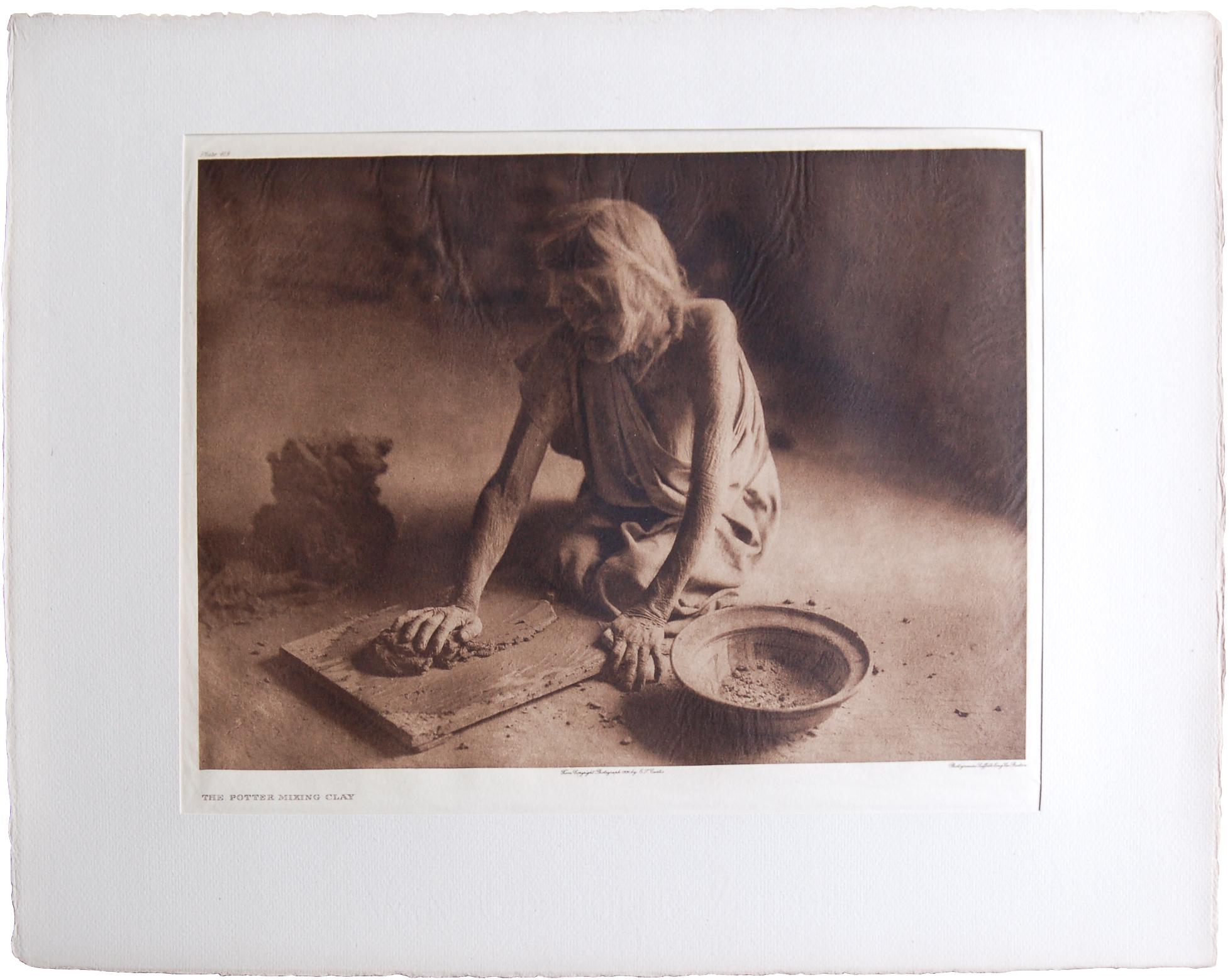 Edward S. Curtis Portrait Photograph - The Potter Mixing Clay, 1921
