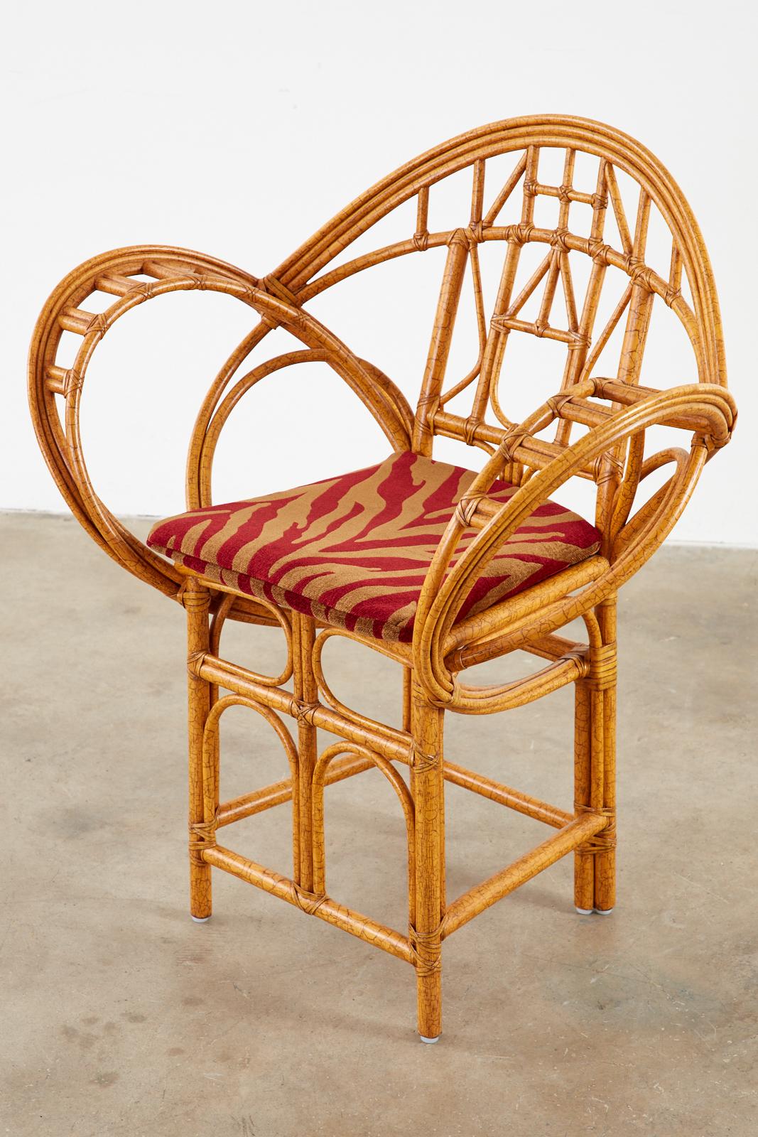 Sculptural bamboo rattan peacock style armchair designed by Edward Tuttle for McGuire. Known as the butterfly chair featuring gracefully curved rattan poles made in the California organic modern style. The rattan is lashed together using leather