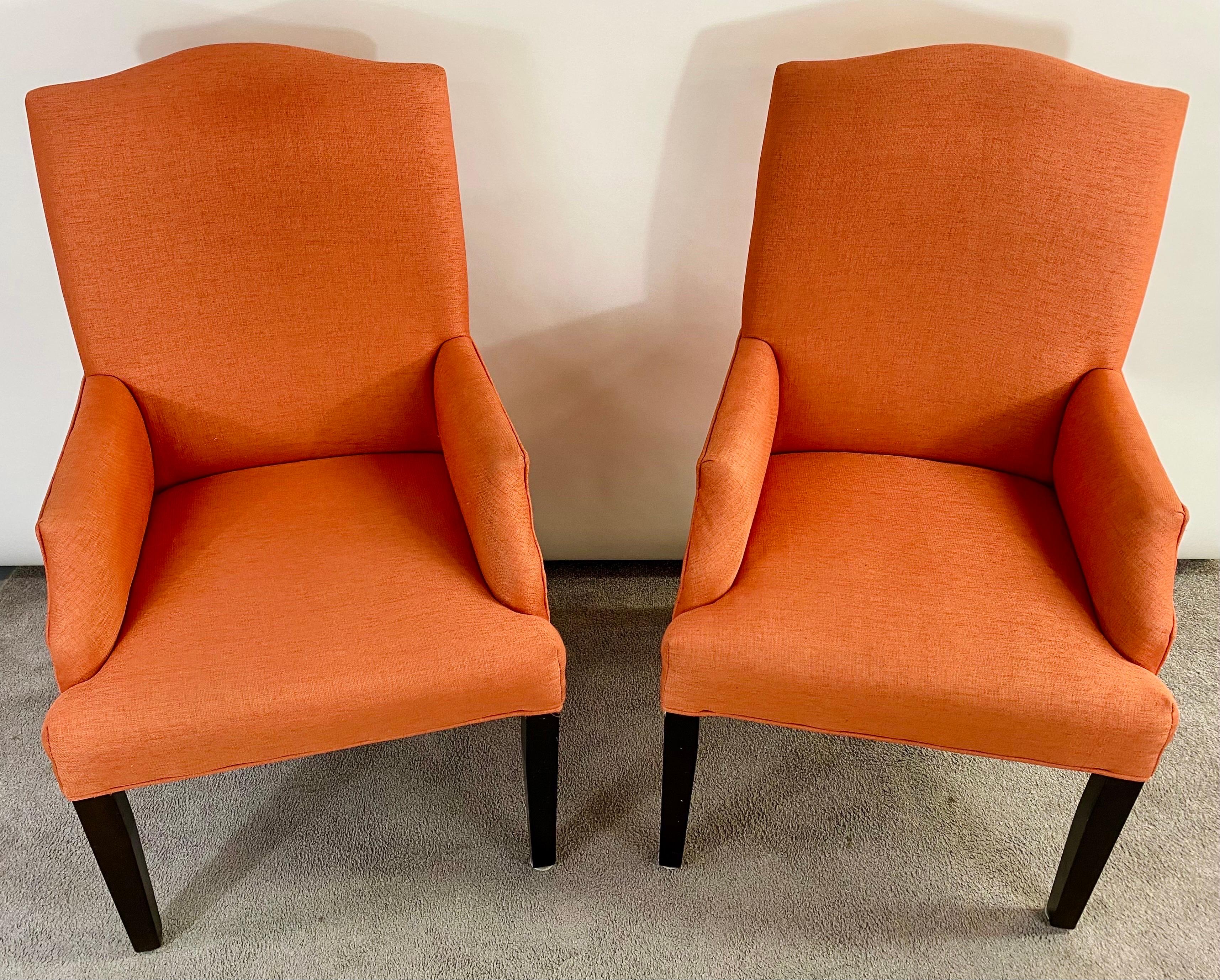 A timeless Mid-Century Modern lounge or side chairs in the style of Edward Wormly ( American , 1907 - 1995). The chairs feature a very stylish orange Hermes color upholstery. The chairs combine both style and comfort with a high back and perfect