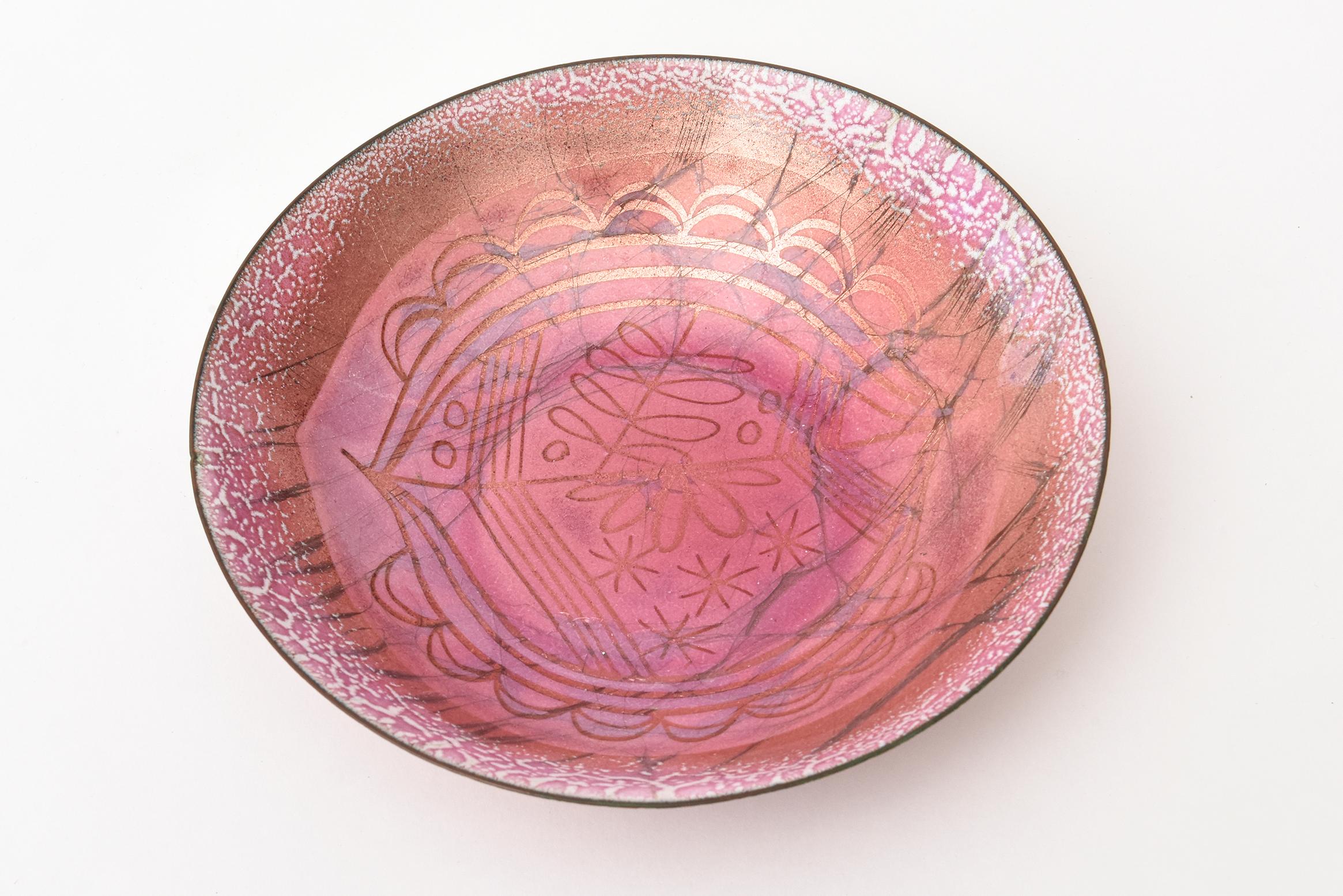 This lovely abstract enamel bowl over copper is signed Winter. It is Mid-Century Modern and the work of Edward Winter. From the 1950s. This is a great object bowl for anywhere with beautiful colors of shades of pink and brown and white. This makes a