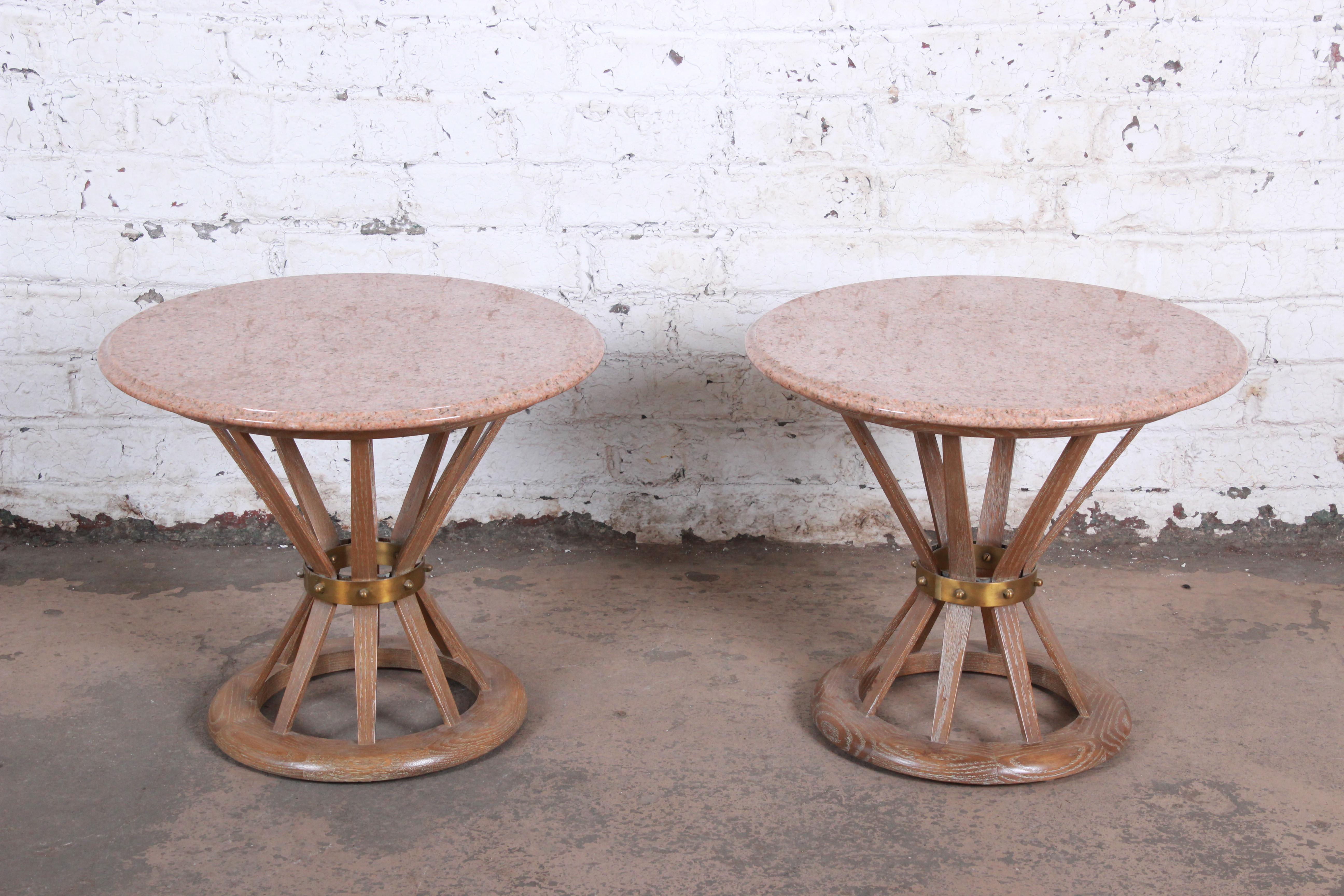 A gorgeous pair of Mid-Century Modern sheaf of white side tables in the manner of Edward Wormley for Dunbar. The tables feature sculpted cerused oak bases in a sheaf of wheat form, with brass bands and stunning beveled pink marble tops with white