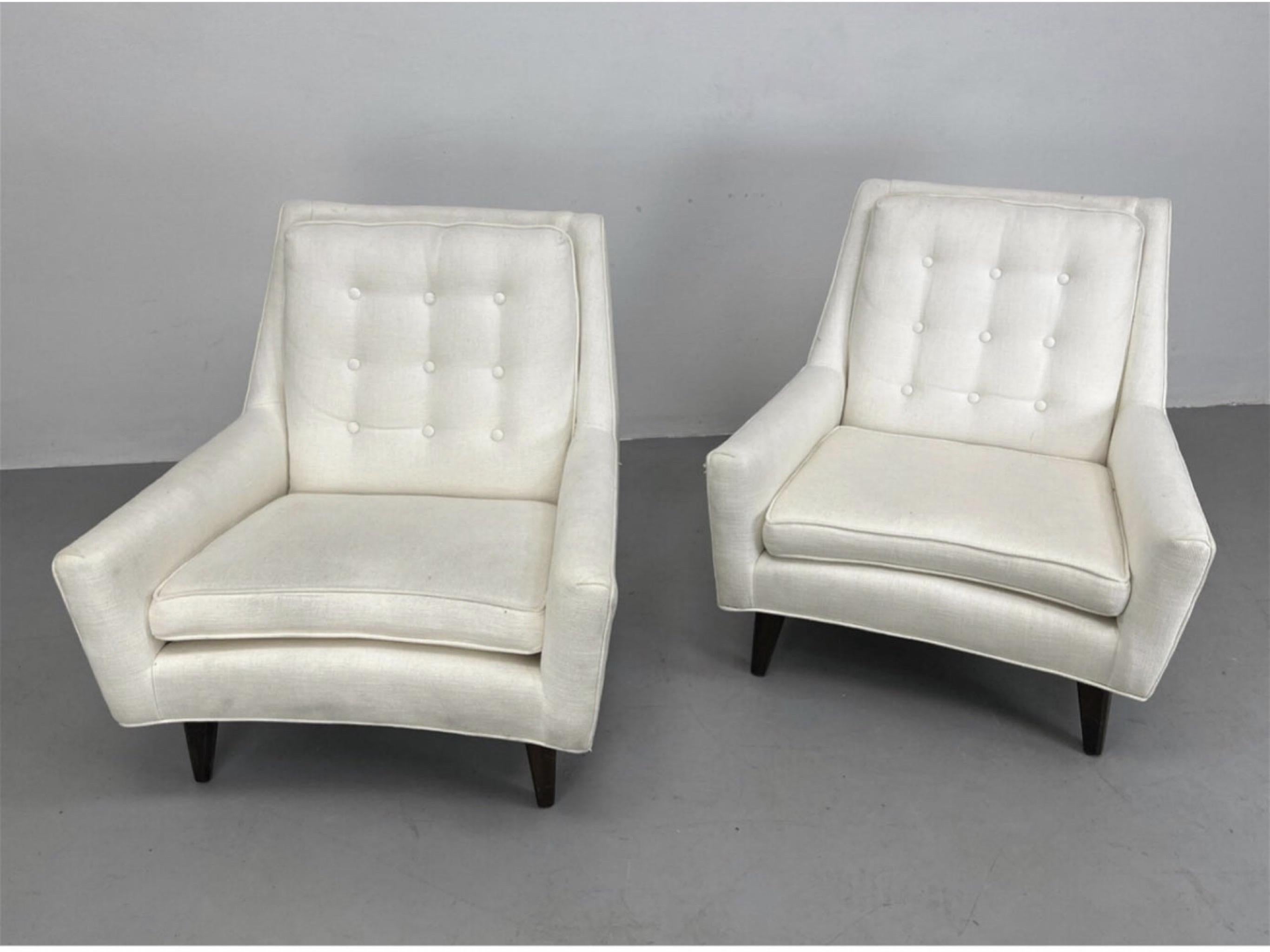 Pair White Upholstered Lounge Chairs in the style of Edward Wormley. Dimensions: H: 31 inches: W: 31 inches: D: 34 inches - Seat Height: 17 inches --- the lines on these are just sexy. Button tufted back cushions and sloping arms.    These chairs