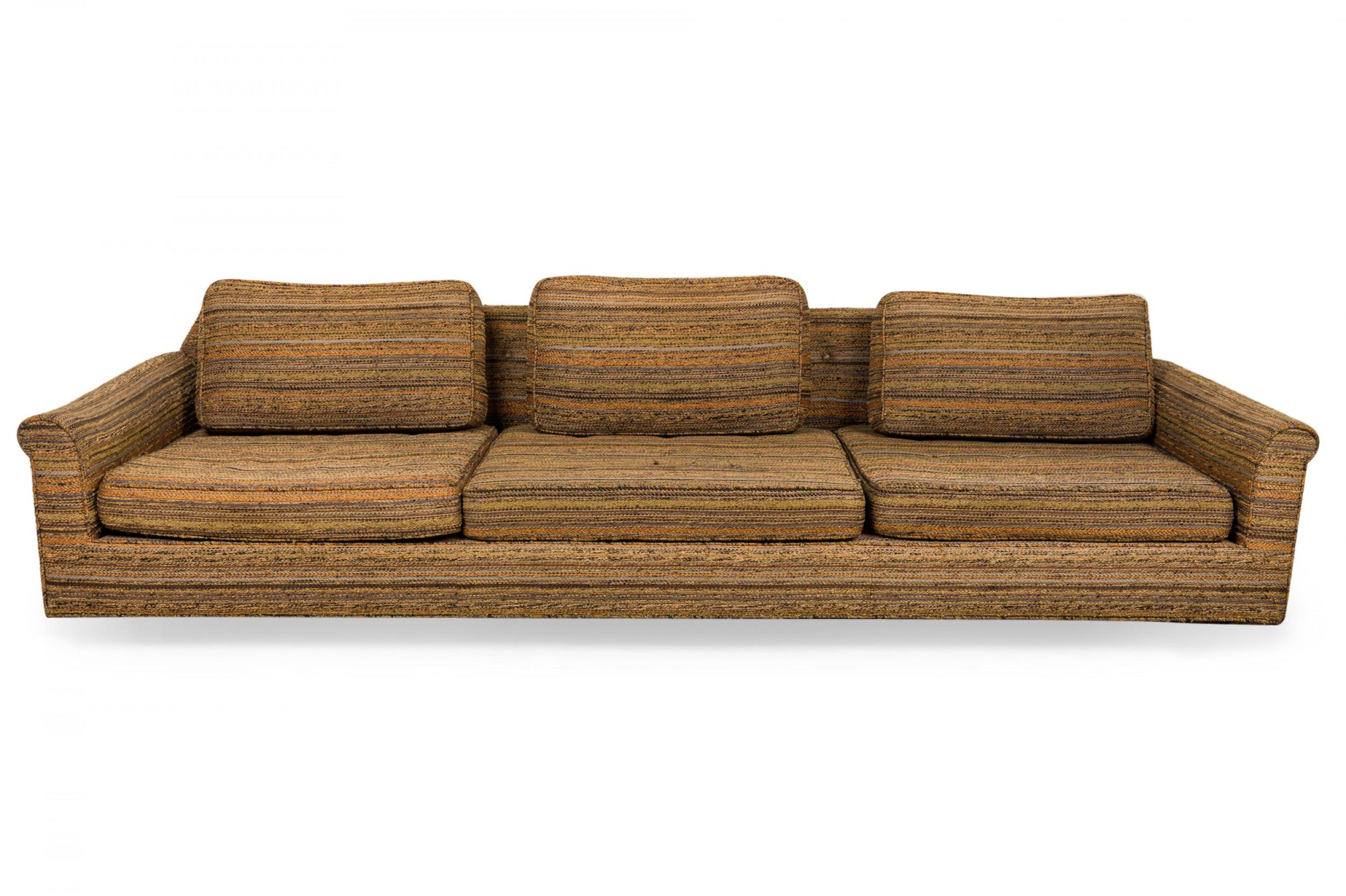 American Mid-Century 'Big Texan' oversized sofa with brown, beige, and green striped textured fabric upholstery and removable seat and back cushions. (EDWARD WORMLEY)
