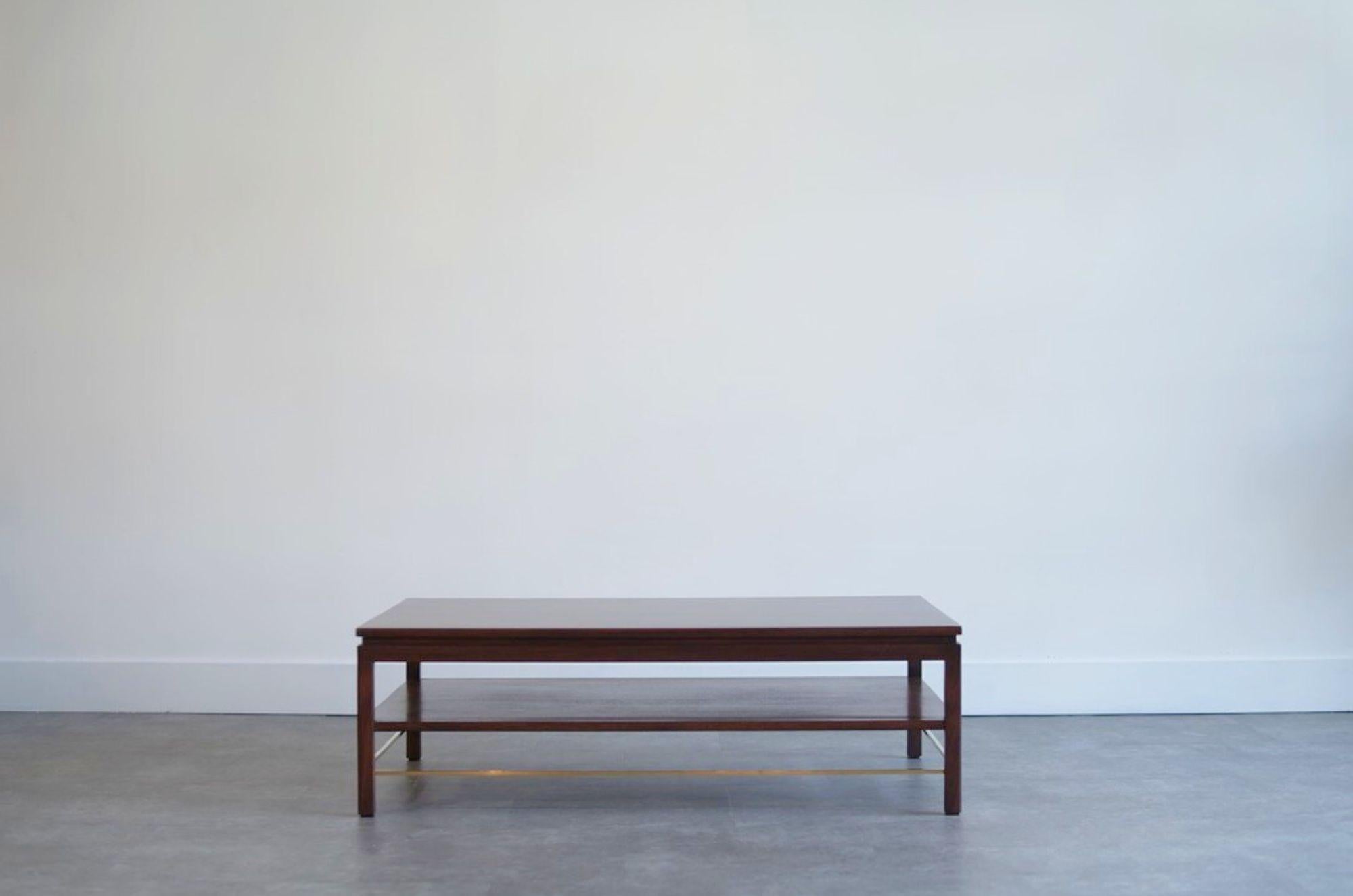 Conçue par l'estimé Edward Wormley pour Dunbar dans les années 1950, cette table basse exquise incarne l'élégance intemporelle et la fonctionnalité moderne. Fabriqué en noyer et en acajou, il présente une silhouette élégante rehaussée par un châssis
