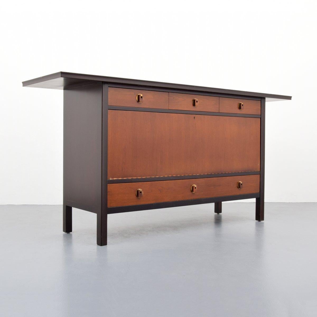 Cabinet by Edward Wormley. Cabinet has three upper drawers and one large lower drawer. Key opens a central door revealing two storage sections, one with an adjustable shelf.

Marking: Dunbar plaque.