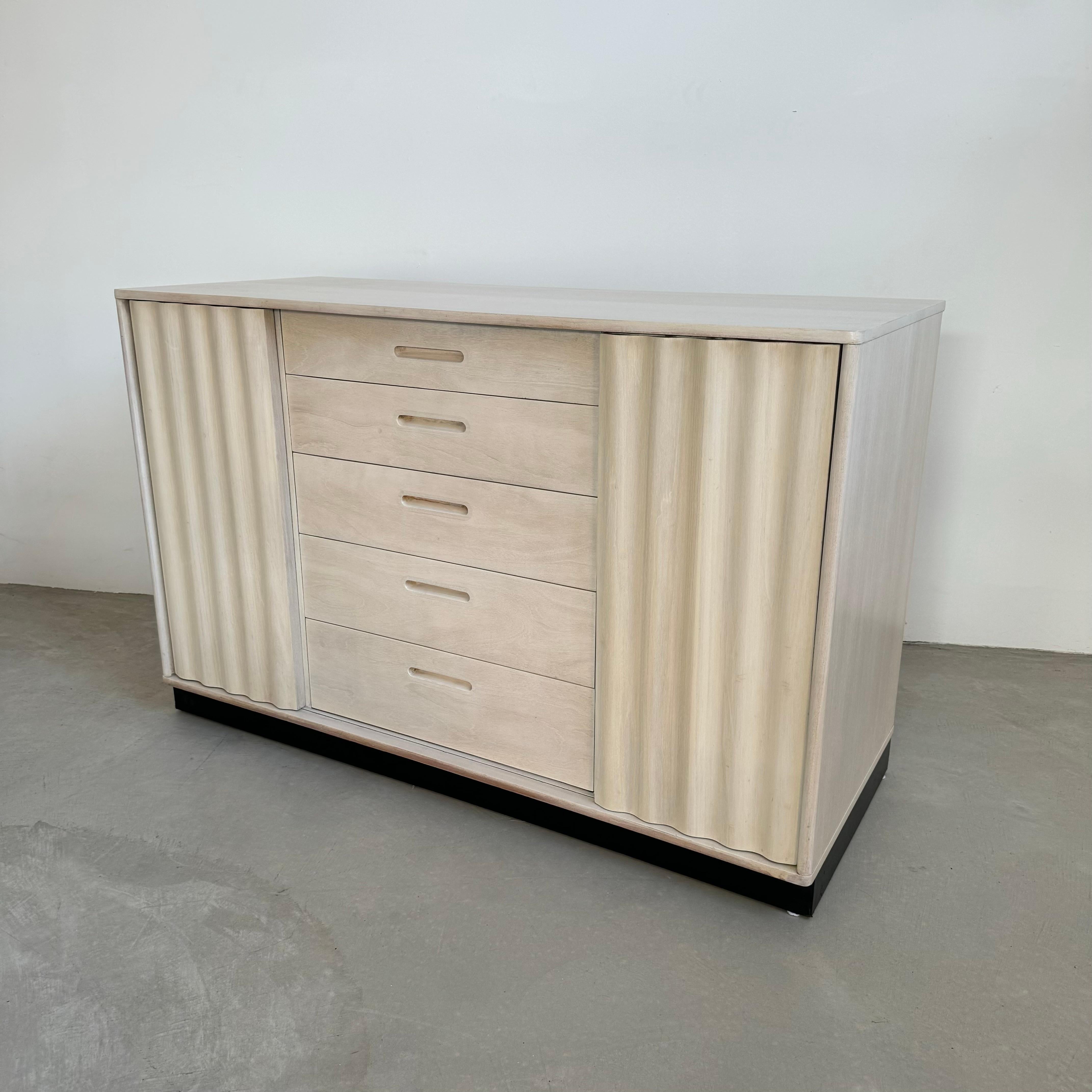 Impresionante armario de roble cerusado de Edward Wormley para Dunbar. Fabricado en EE.UU. en la década de 1950. La parte inferior del mueble es un zócalo envuelto en cuero negro. 

Dos tablones ondulados deslizantes adornan cada lado del mueble