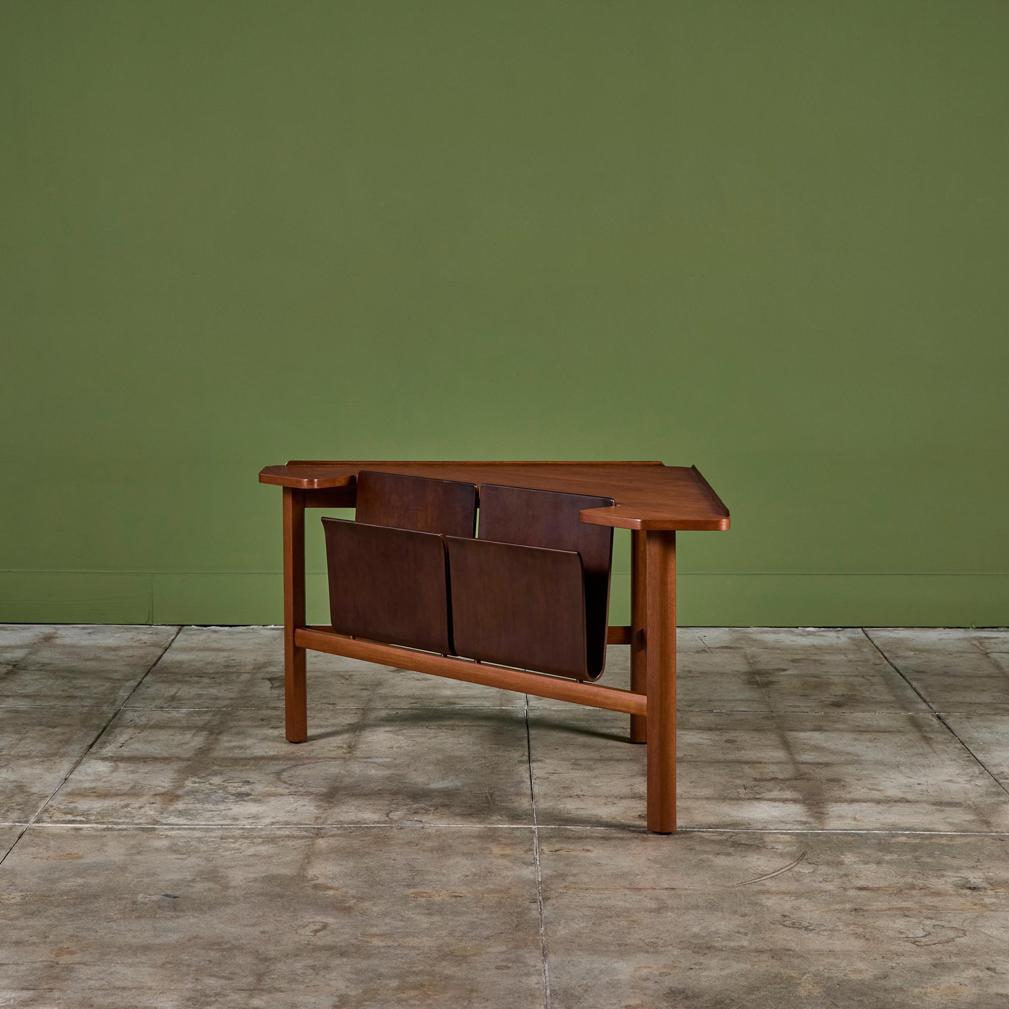 Triangular walnut and mahogany corner side table by Edward Wormley for Dunbar c.1940s, USA. The table, model - 5634, showcases a triangular table top with rounded corners and a double sleeve magazine rack for storage/display.  Retains the Dunbar