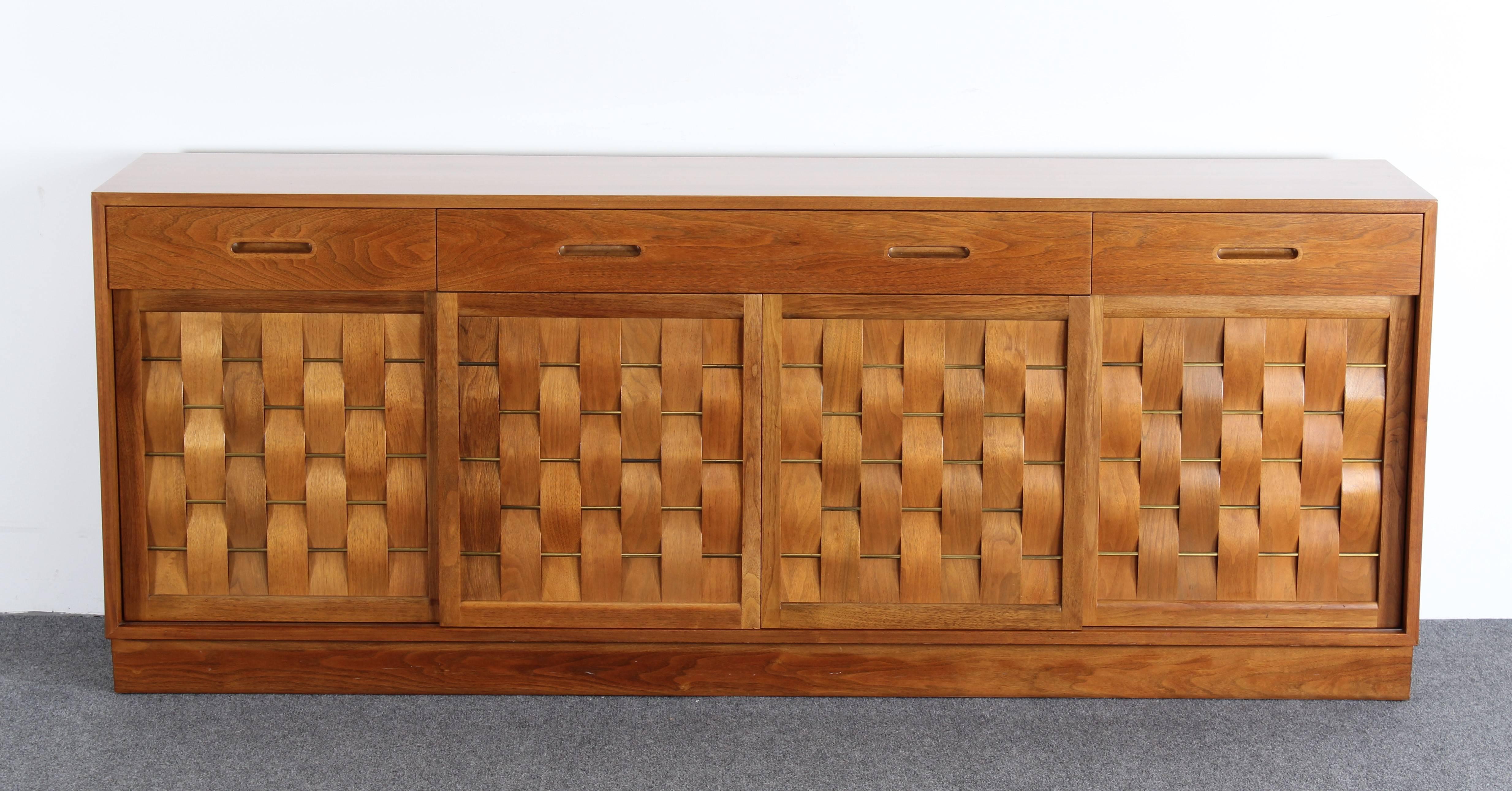 A stunning four door and four drawer woven front cabinet or credenza with brass accents designed by Edward Wormley for Dunbar.