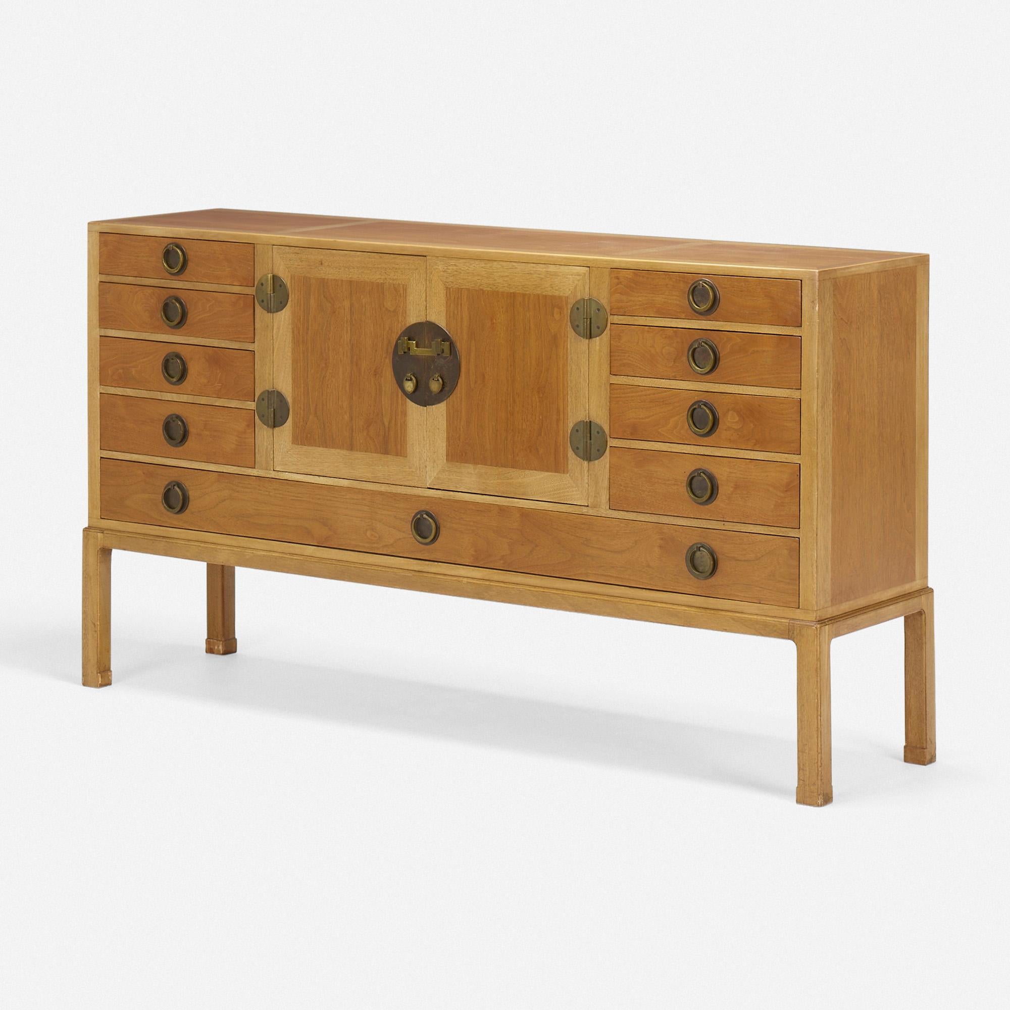 Made by: Dunbar, USA, 1945

Material: bleach mahogany, walnut, brass, glass

Size: 70 w × 18.5 d × 38 h in

Description: Model 4579. Credenza features nine drawers with two center doors concealing pull out tray.