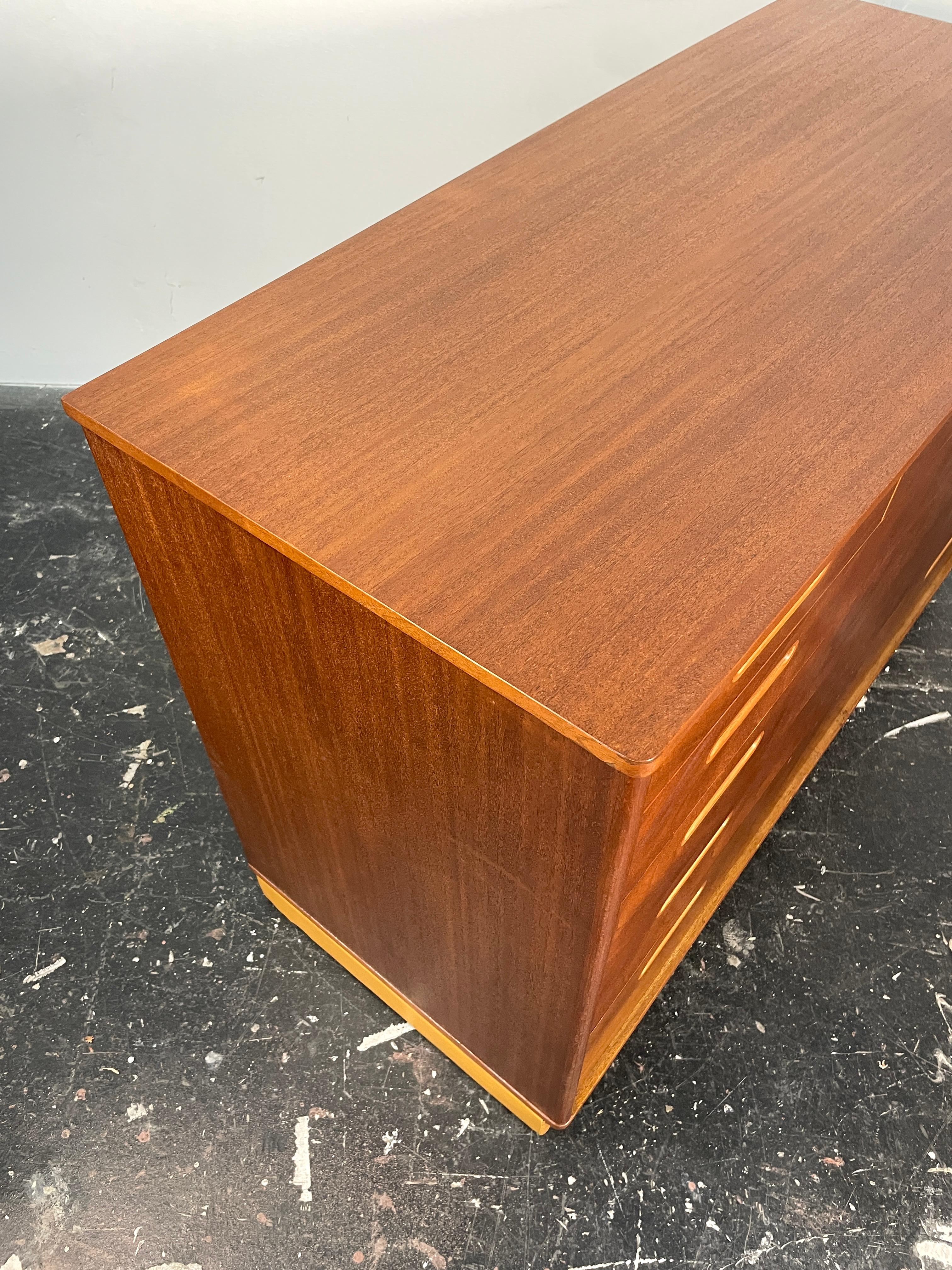 Uncommon Edward Wormley Dresser in Mahogany and Leather for Dunbar. Gorgeous restored vintage dresser with contrasting channelled recessed pulls in contrasting wood species. This pieces also features a luxurious wheat leather-wrapped plinth base and