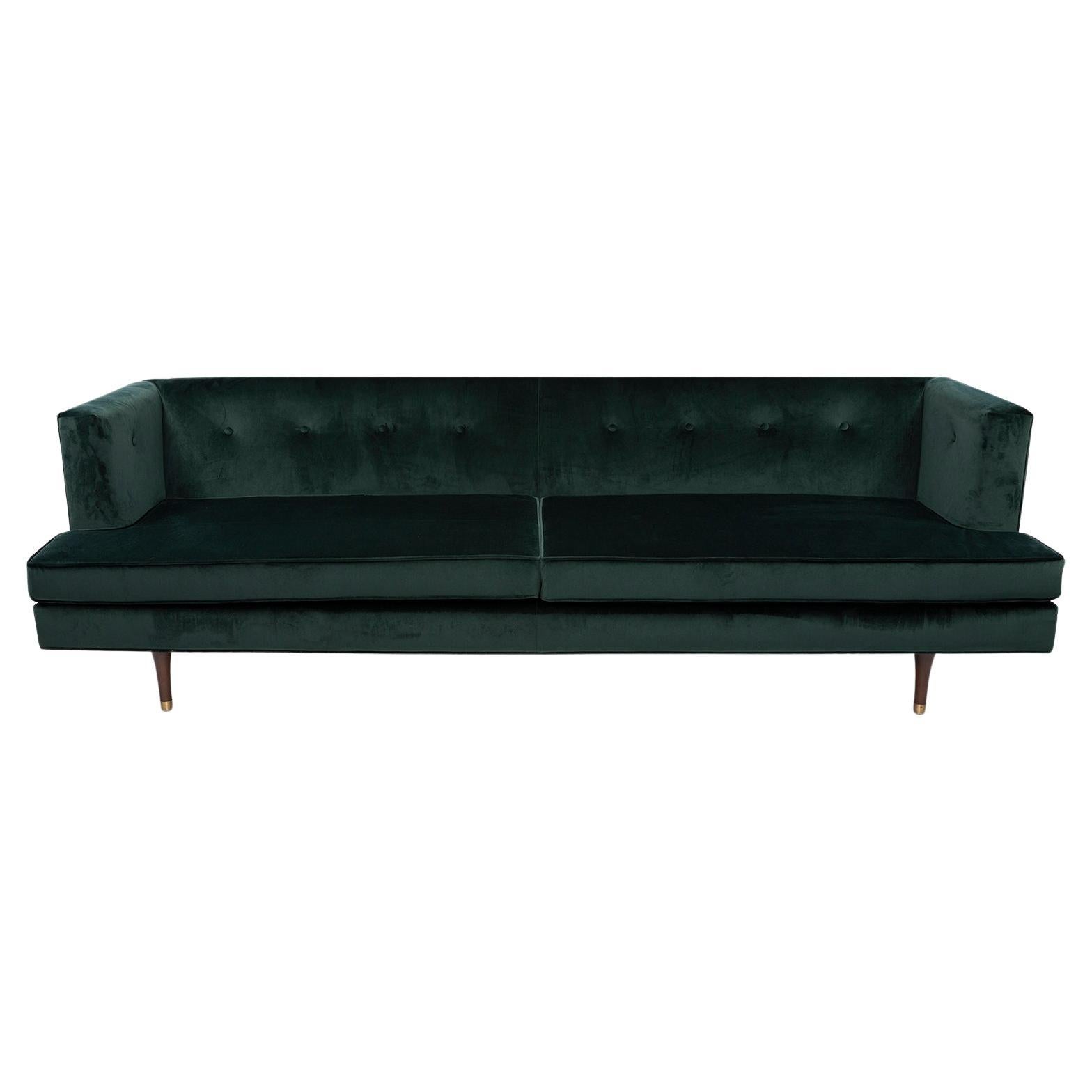 Edward Wormley for Dunbar sofa number 4908 circa early 1940s. This example has been masterfully upholstered in a wonderful dark emerald green mohair. This fabric melds seamlessly with the newly finished solid walnut and brass legs. Excellent