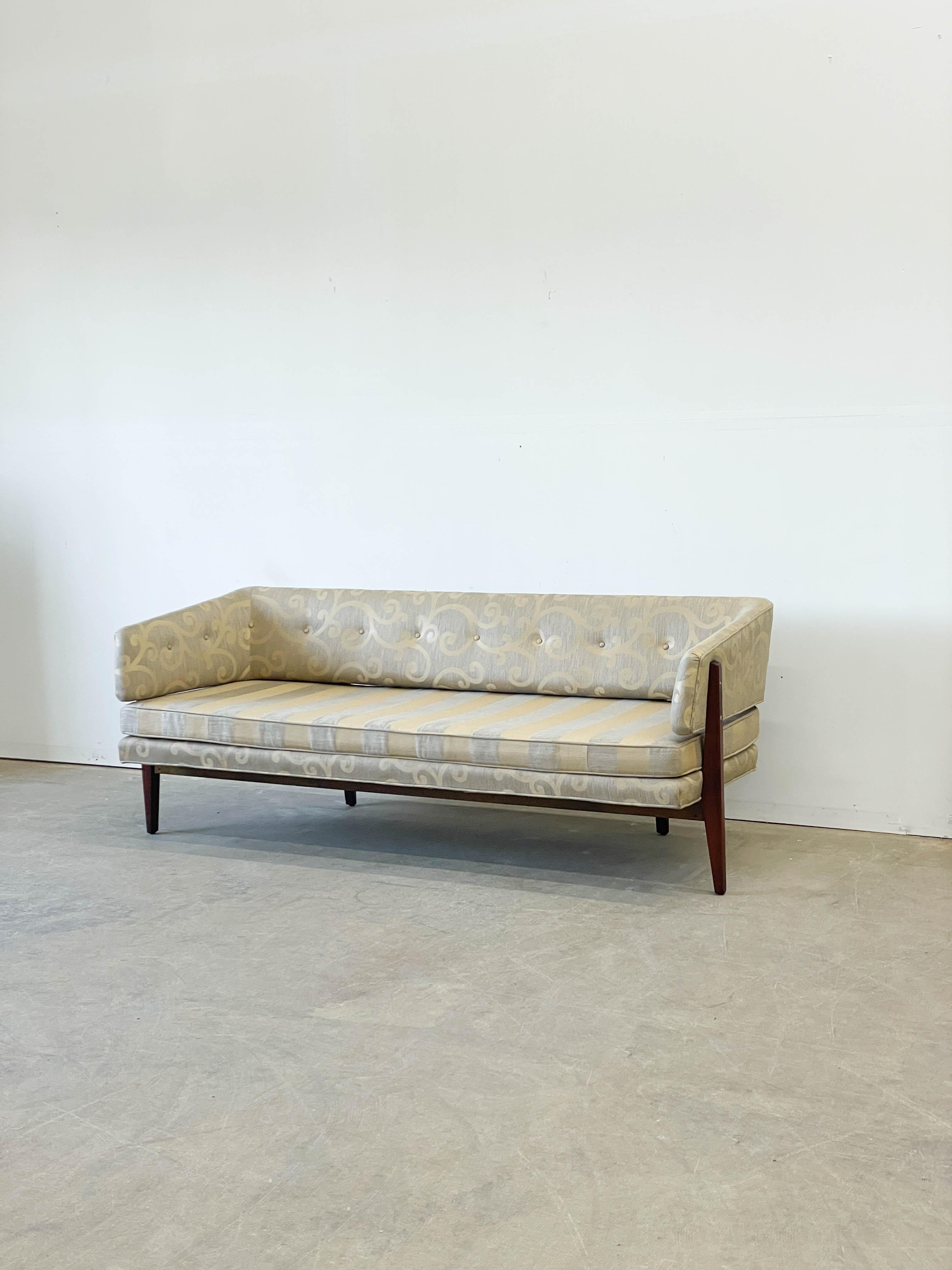 Rare 1950s sofa design by Edward Wormley for Dunbar featuring a beautiful exposed mahogany frame and a floating arm and back section. Showcasing Wormley's deft skill of transforming traditional seating forms into modern classics, this sofa is a real