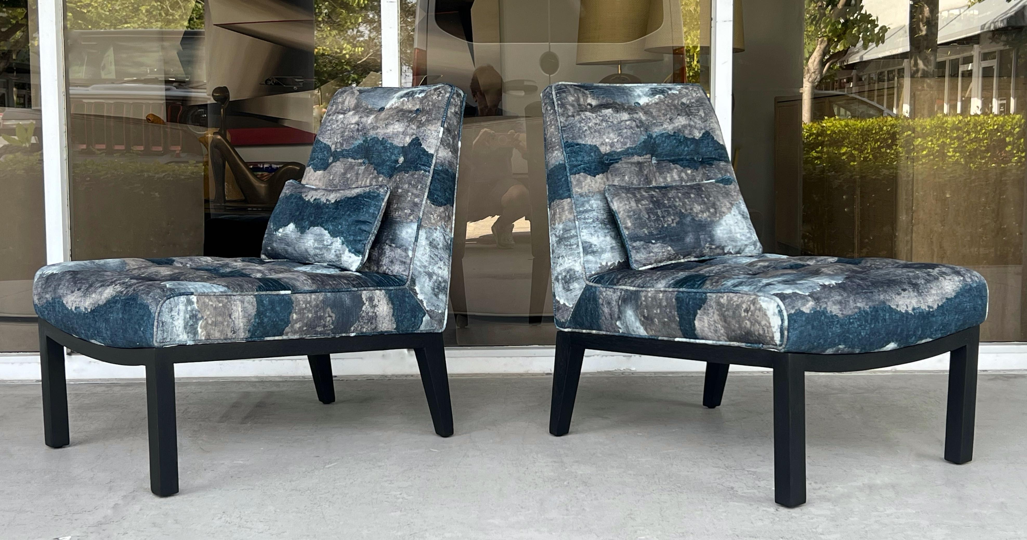 Un llamativo par de sillas slipper Modernas de Mediados de Siglo diseñadas por Edward Wormley para Dunbar, de líneas limpias y arquitectónicas y excepcional artesanía. Las sillas descansan sobre bases de madera maciza ebonizada, que proporcionan un