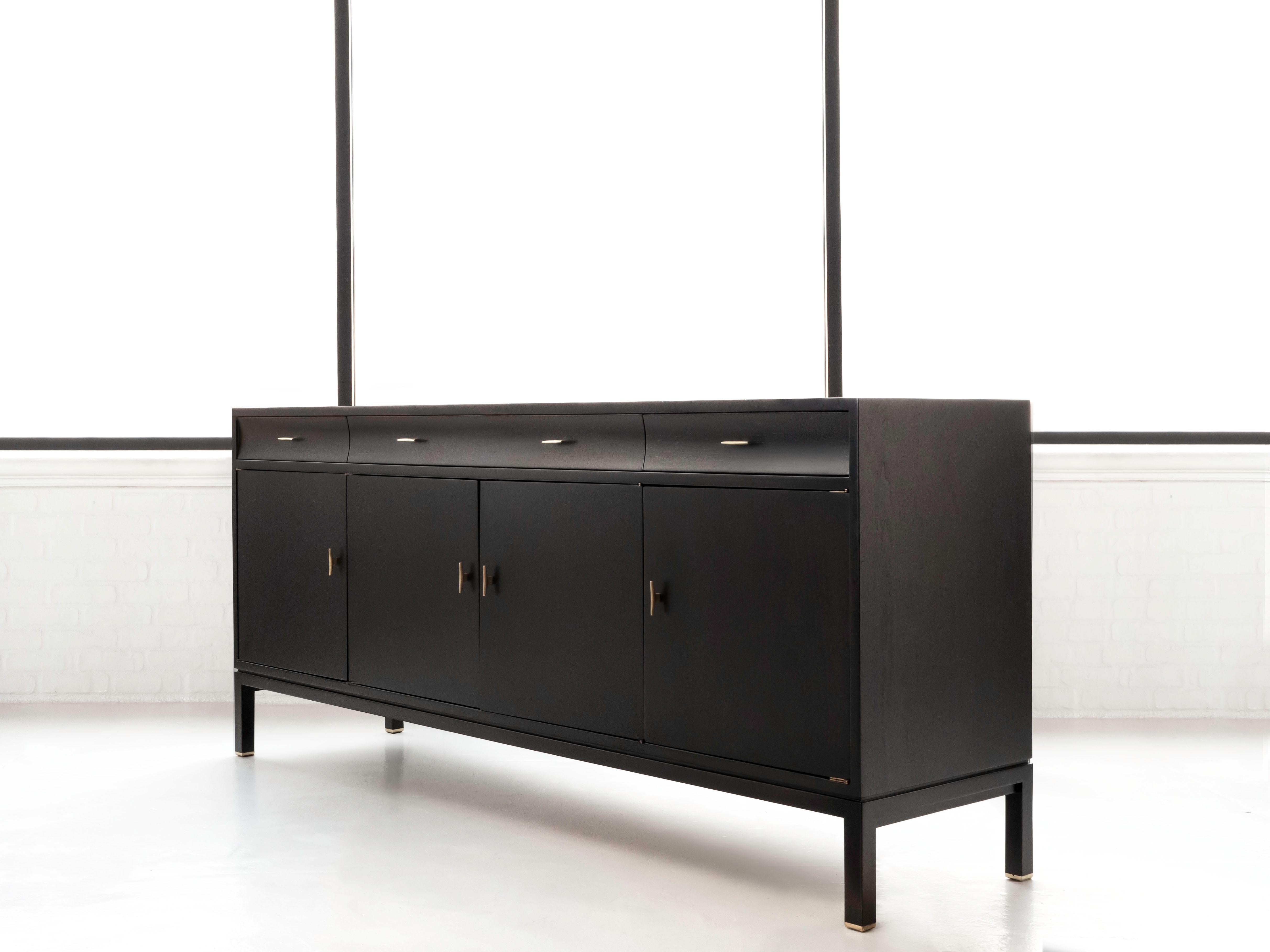 Edward Wormley sideboard / credenza in ebonized walnut.  Made for Dunbar and signed on the interior draw.  This piece has been fully refinished, the ebonized wood shows very nice.  The walnut underneath creates a dark espresso tone.

Solid brass