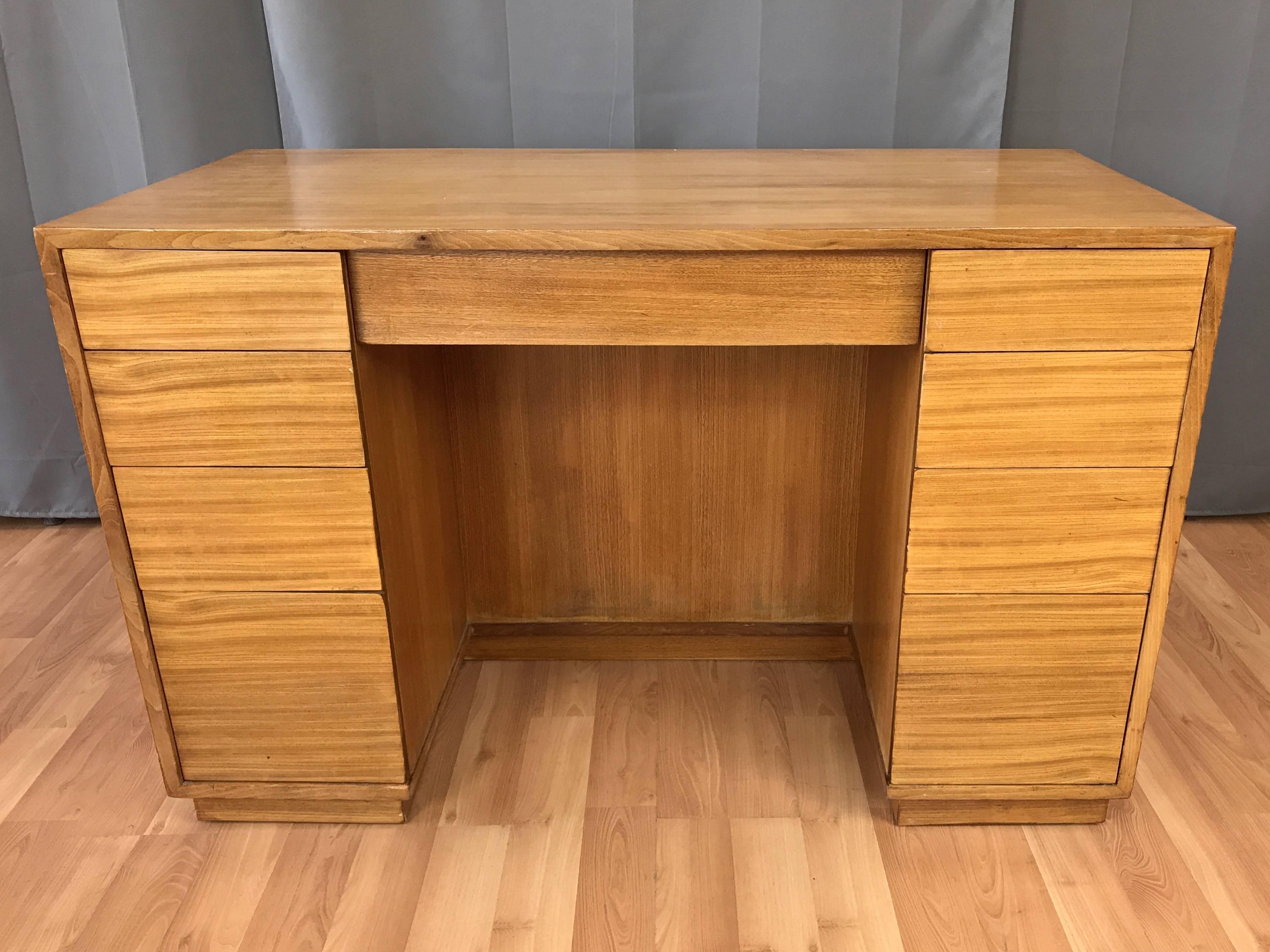 An uncommon Mid-Century Modern elm desk by Edward Wormley from his Precedent Collection for Drexel.

Clean-lined and compact design features nine drawers with hidden pulls and a pair of cubbies. Top left & right drawers have open sides, allowing