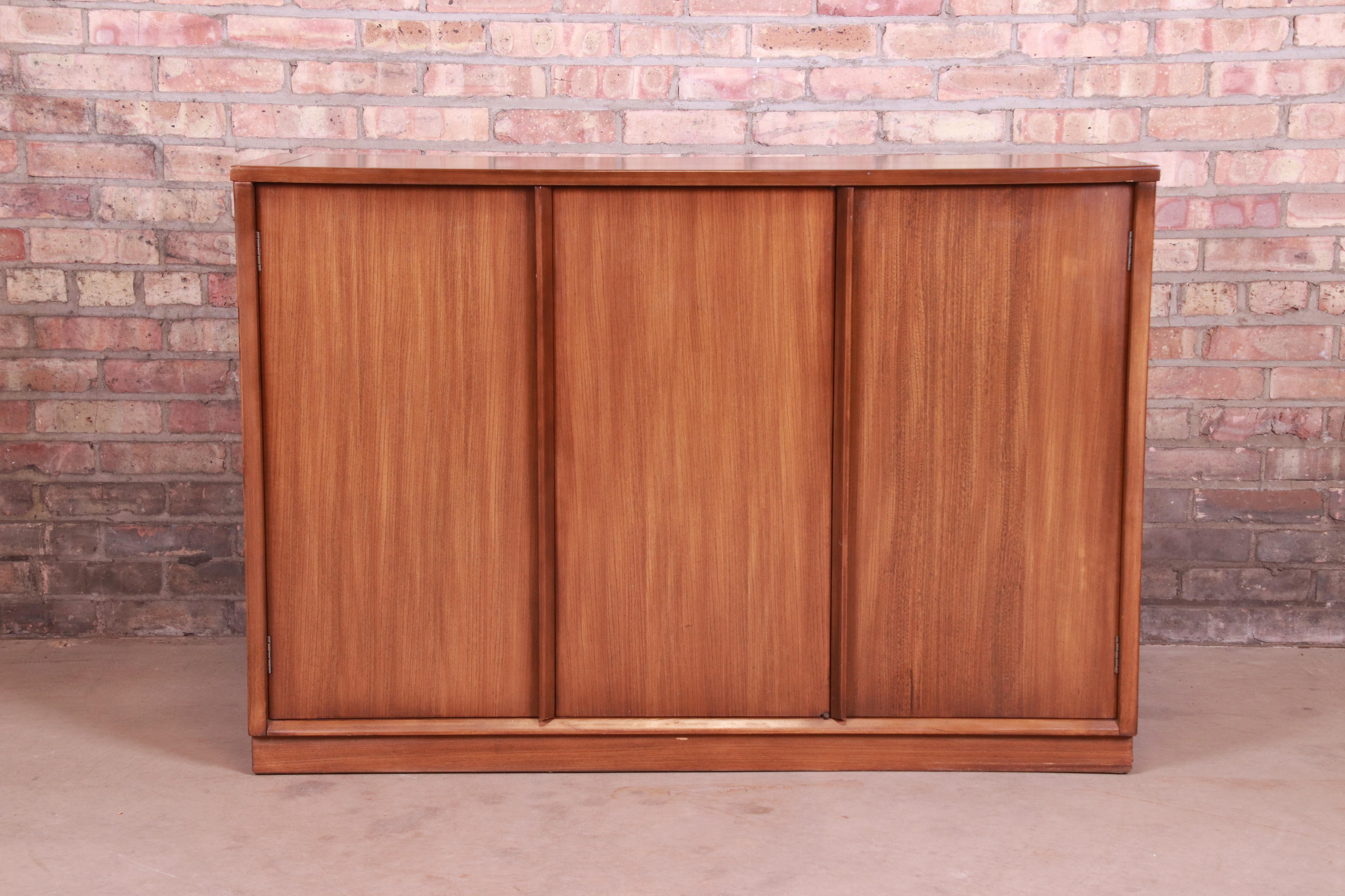 A sleek and stylish Mid-Century Modern elm wood sideboard server, credenza, or bar cabinet

By Edward Wormley for Drexel 