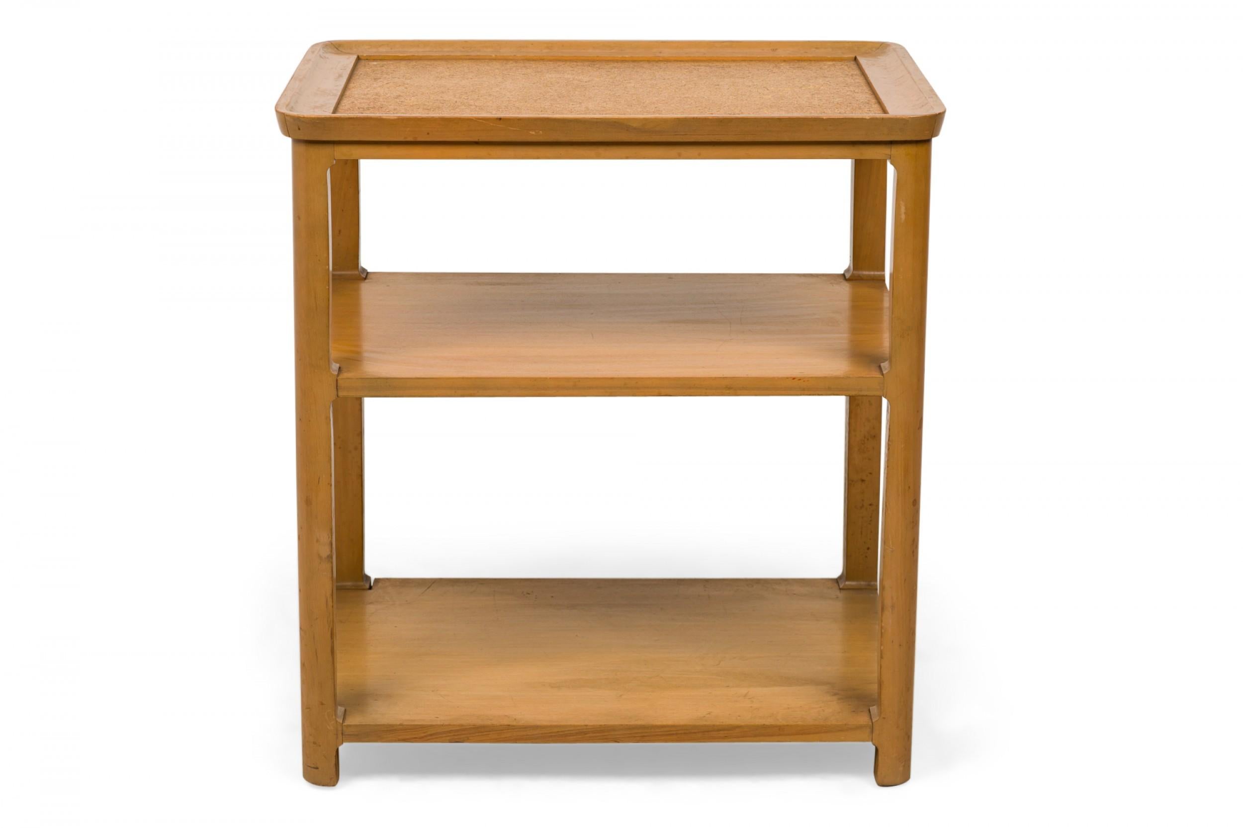 Pair of American mid-century rectangular three-tier end / side tables with blonde wood frames with rounded edges and an inset cork top with two wooden shelves below. (EDWARD WORMLEY FOR DREXEL)(PRICED AS PAIR)