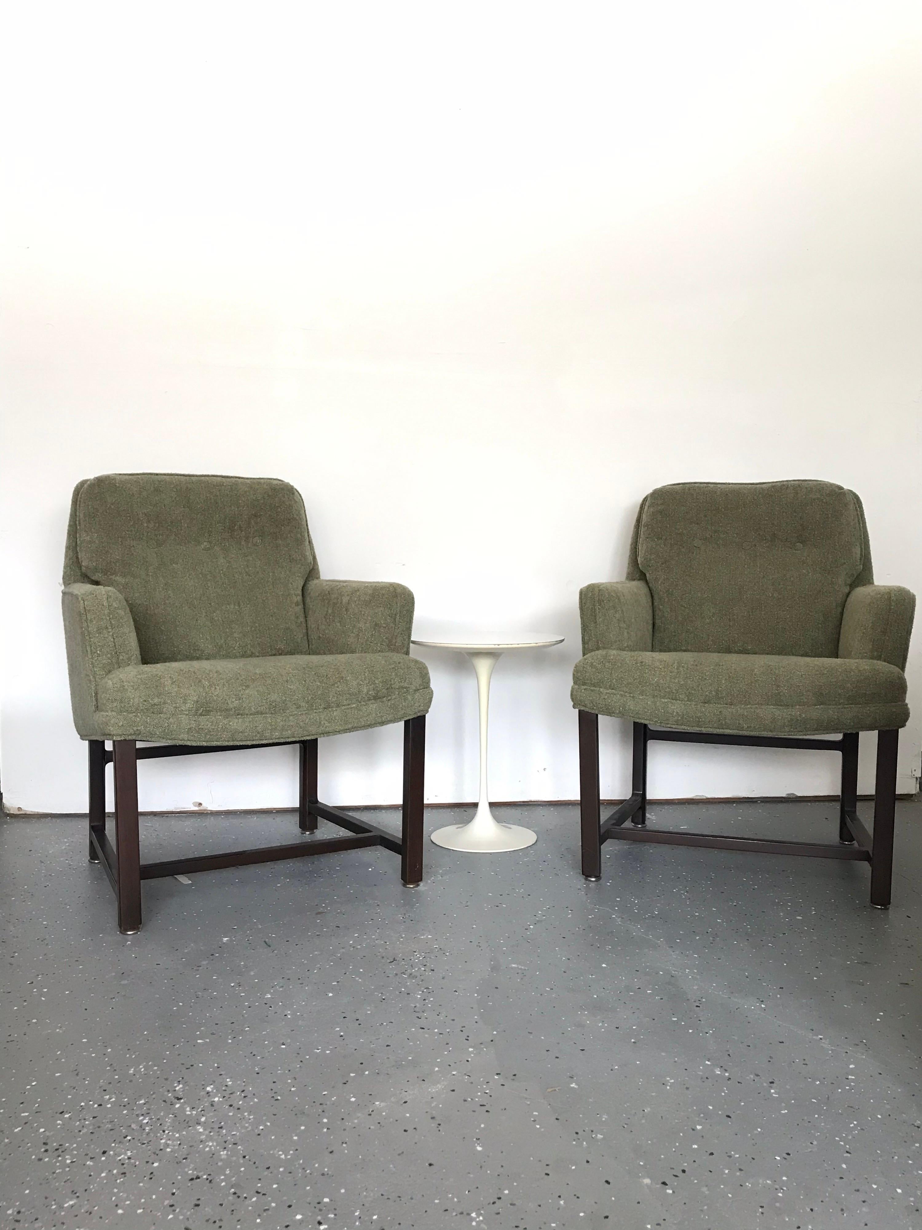 Multiple applications for this unusual pair of armchairs/ loungers by Edward Wormley for Dunbar Furniture. Chairs feature a nubby sage green upholstery over a dark mahogany frame. Chairs are deceivingly large in scale. Please reference the picture