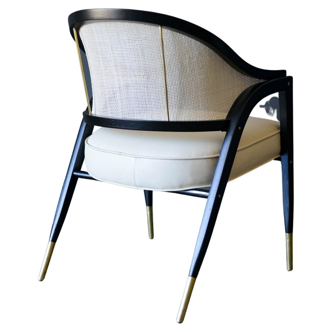 Edward Wormley for Dunbar style 5480 sculpted armchair, circa 1955. Fully restored, ebonized frame with new ivory leather upholstery and new cane back. Beautiful brass detailing has been polished and shines with no rust. Rare, hard to find in this