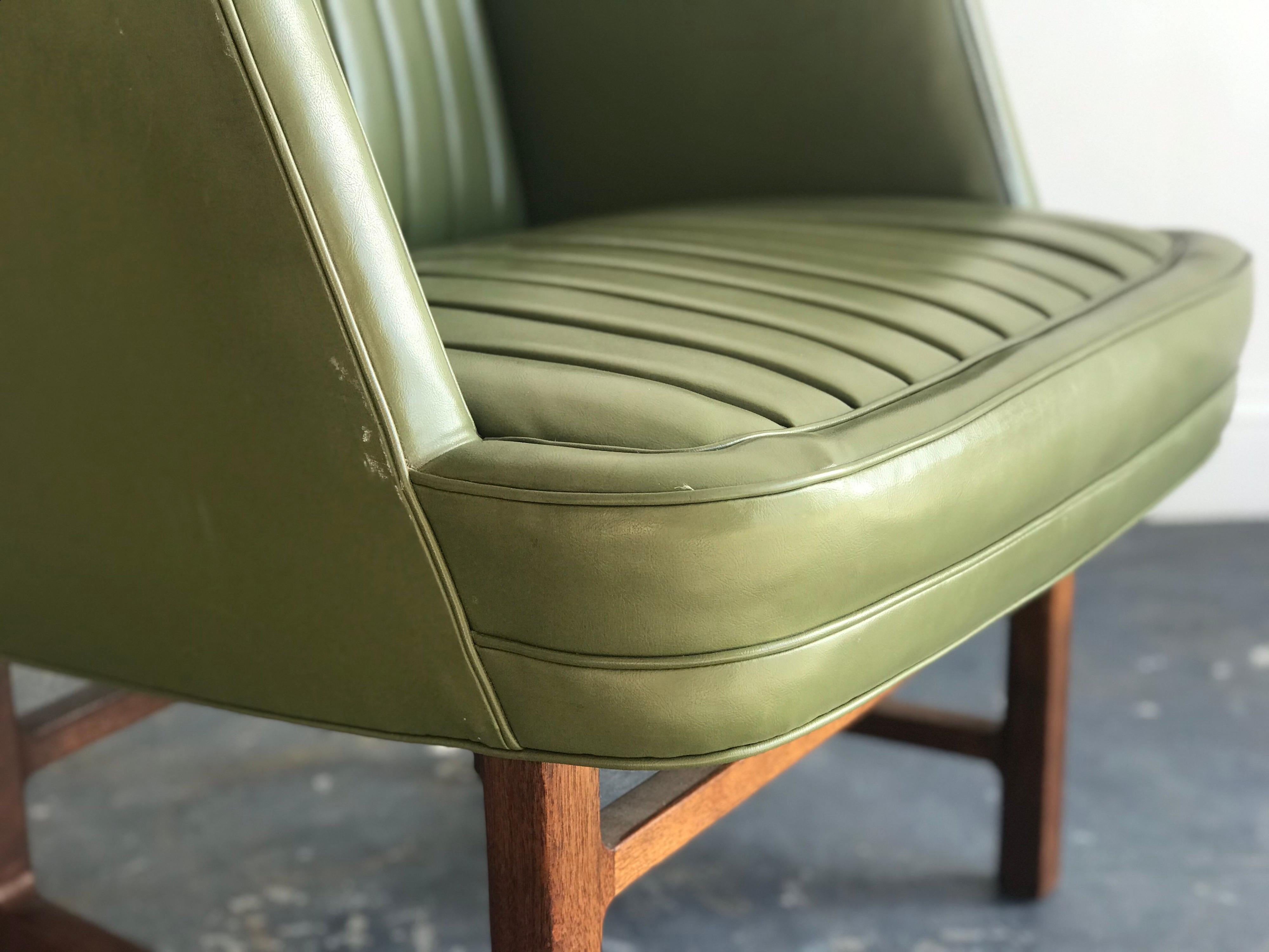 Unusual chair in leather and walnut by Edward Wormley for Dunbar. Fantastic walnut base with detailing consistent with his “Janus” line. Leather appears original and presents exceptionally well.