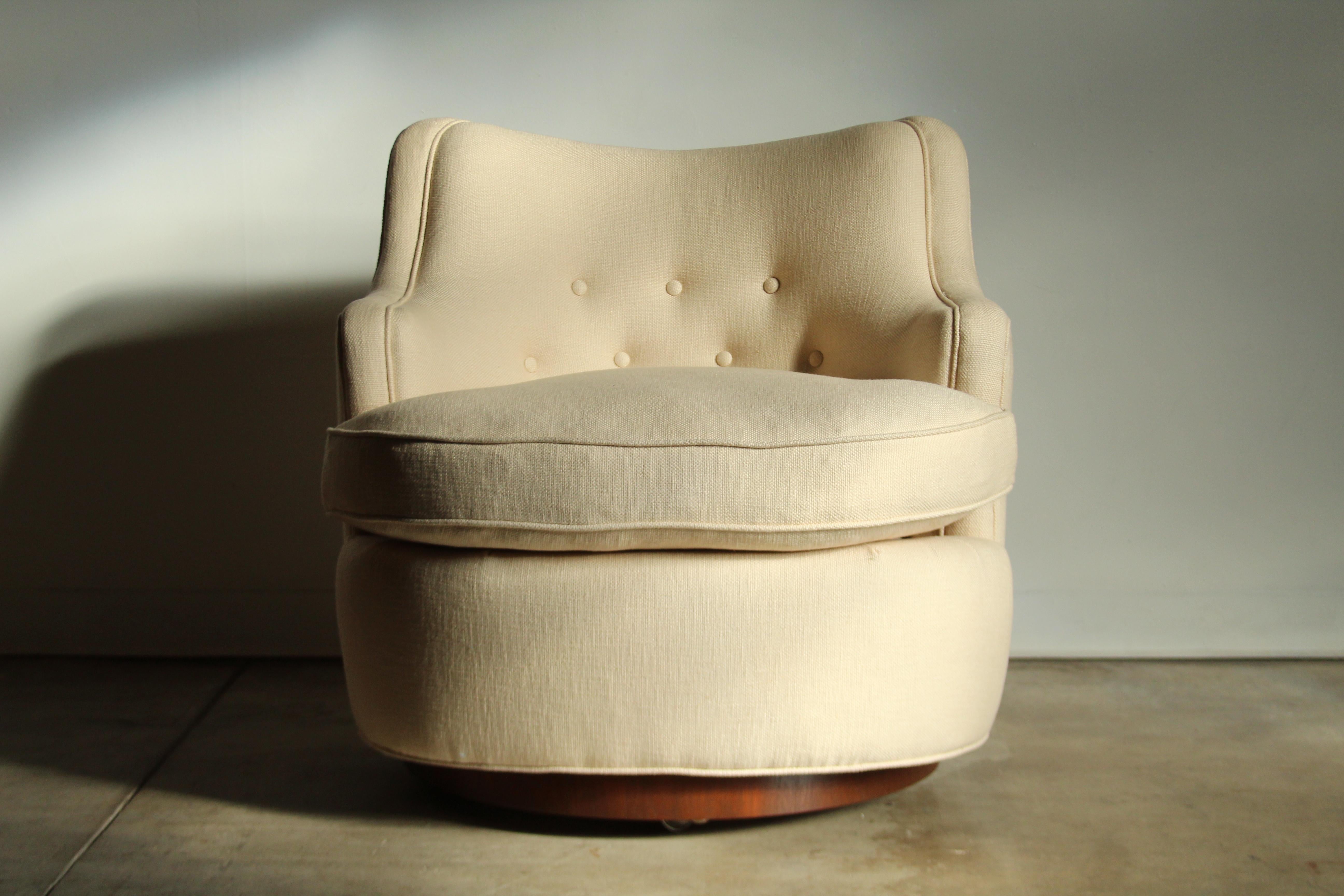 Dieser große, klobige Barrel Chair wurde von Edward Wormley entworfen und von Dunbar in den späten 1940er Jahren hergestellt. Der abgerundete Körper steht auf einem runden Sockel aus Nussbaumholz, der auch über versteckte Rollen verfügt. Eine