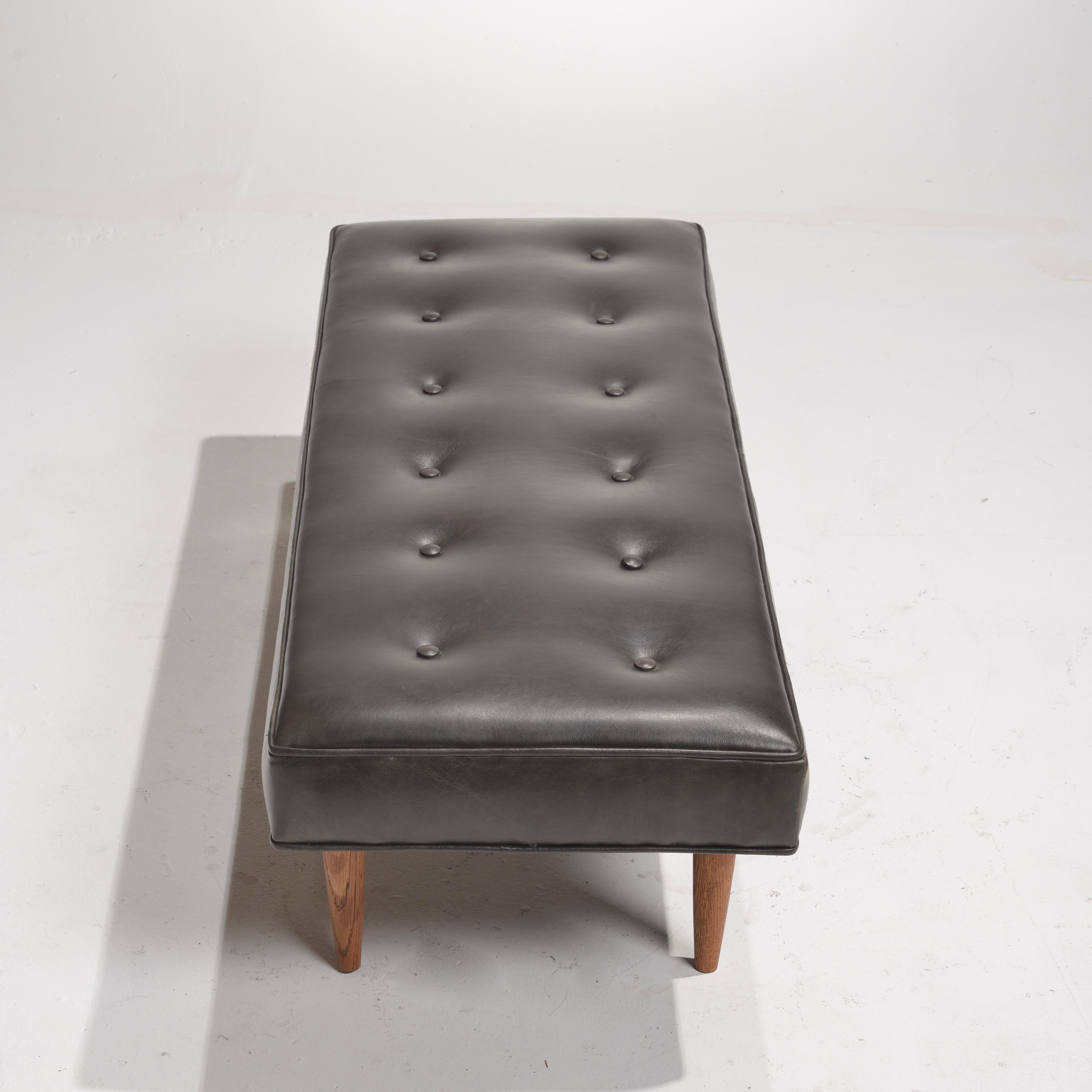 This wonderful bench was designed for Dunbar by Edward Wormely, c1960.  Newley upholstered in dark grey/black Italian leather.  On display in our Los Angeles showroom.  