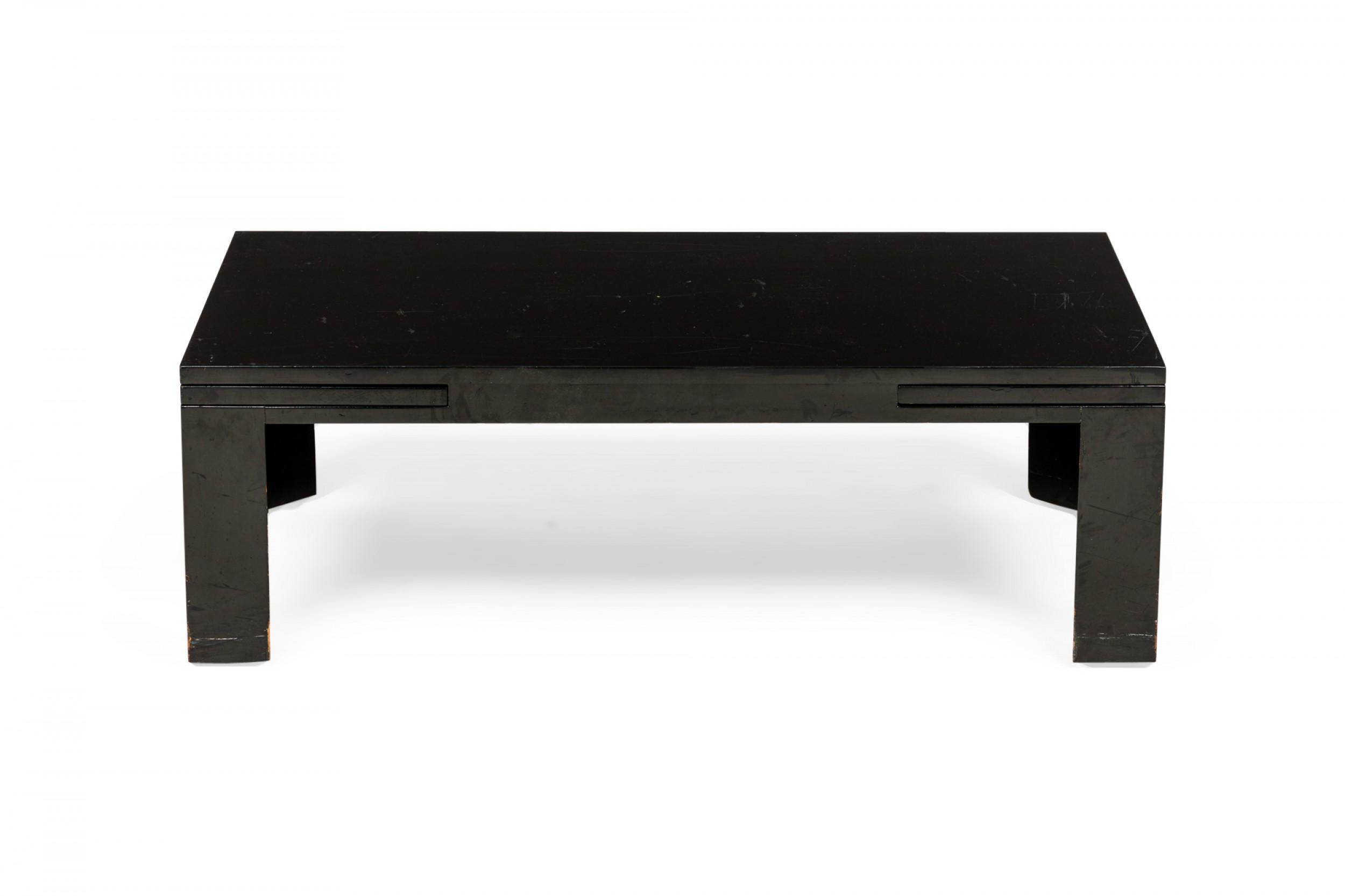 American Mid-Century black painted wooden refectory coffee / cocktail table with a rectangular top and two concealed pull out leaves on either side. (EDWARD WORMLEY FOR DUNBAR FURNITURE COMPANY).