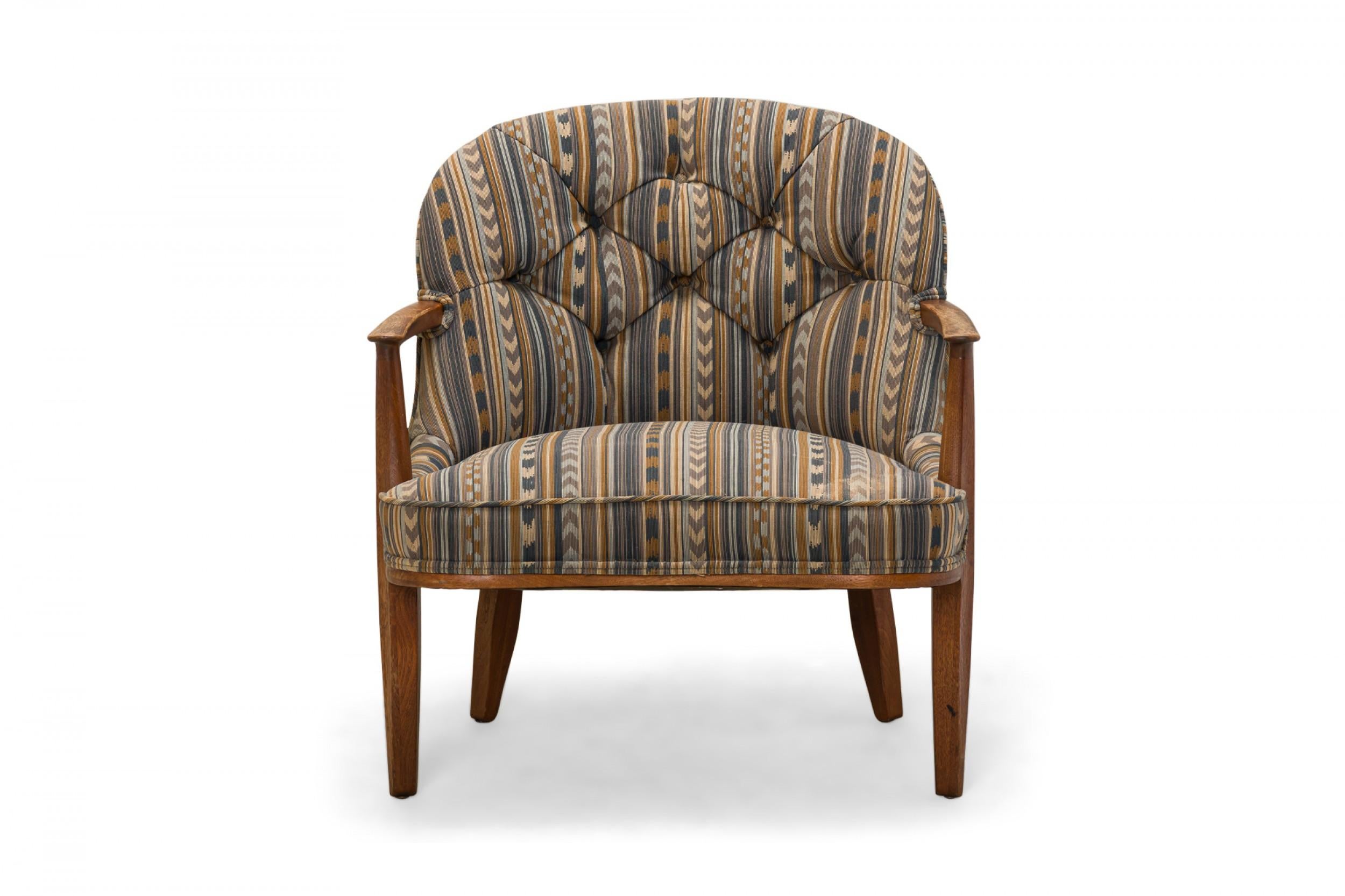 American Mid-Century 'Janus' lounge / armchair with a walnut frame and blue, beige, and brown geometric stripe patterned fabric upholstery with a button tufted back, resting on four slightly tapered walnut legs. (EDWARD J WORMLEY FOR DUNBAR