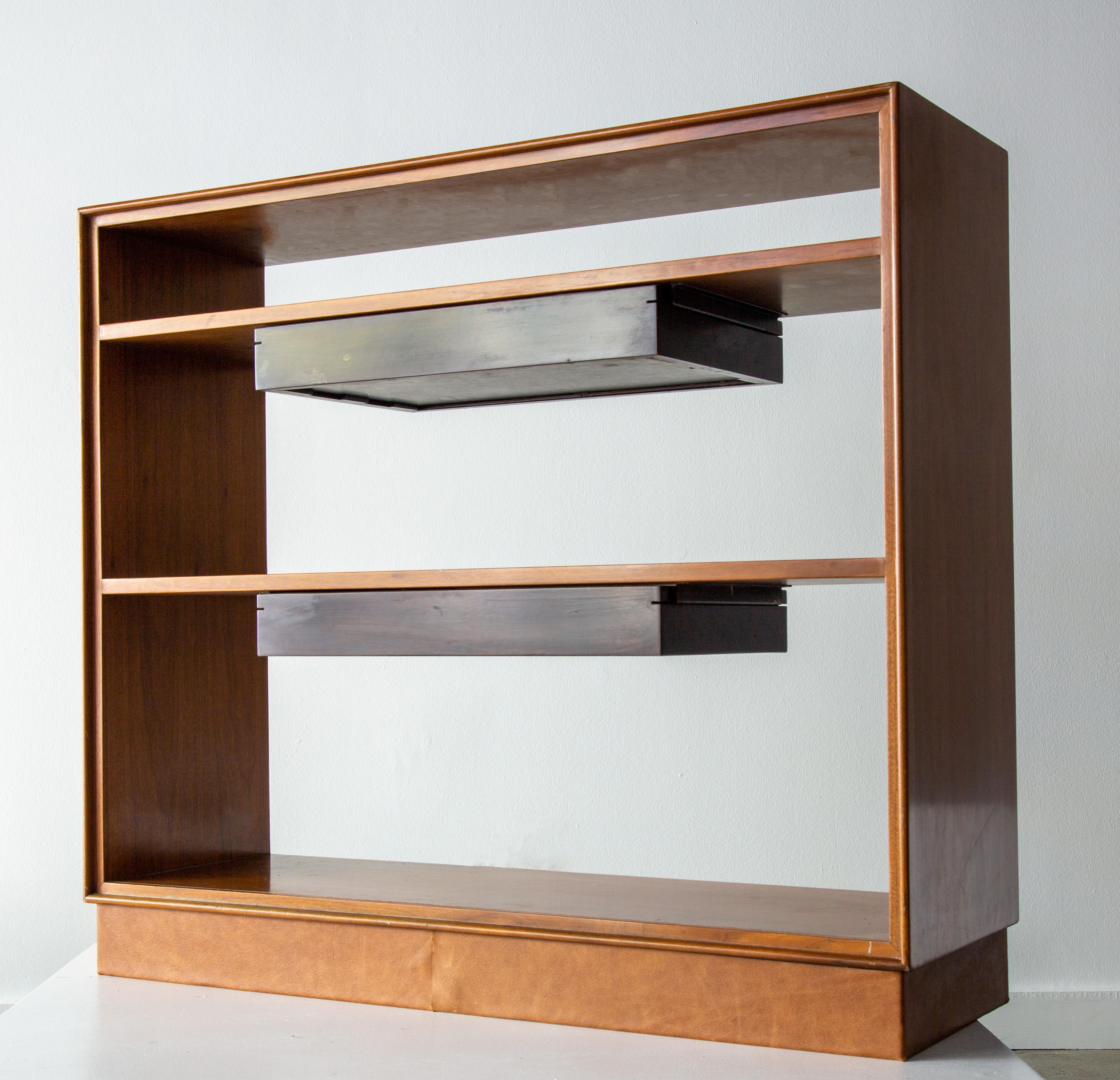A rare bookcase designed by Edward Wormley for Dunbar, model no. 686. This bookcase features a mahogany case with subtle fluted edge profile. The suspended drawers are finished in a contrasting stain and accentuate the architectural features. The