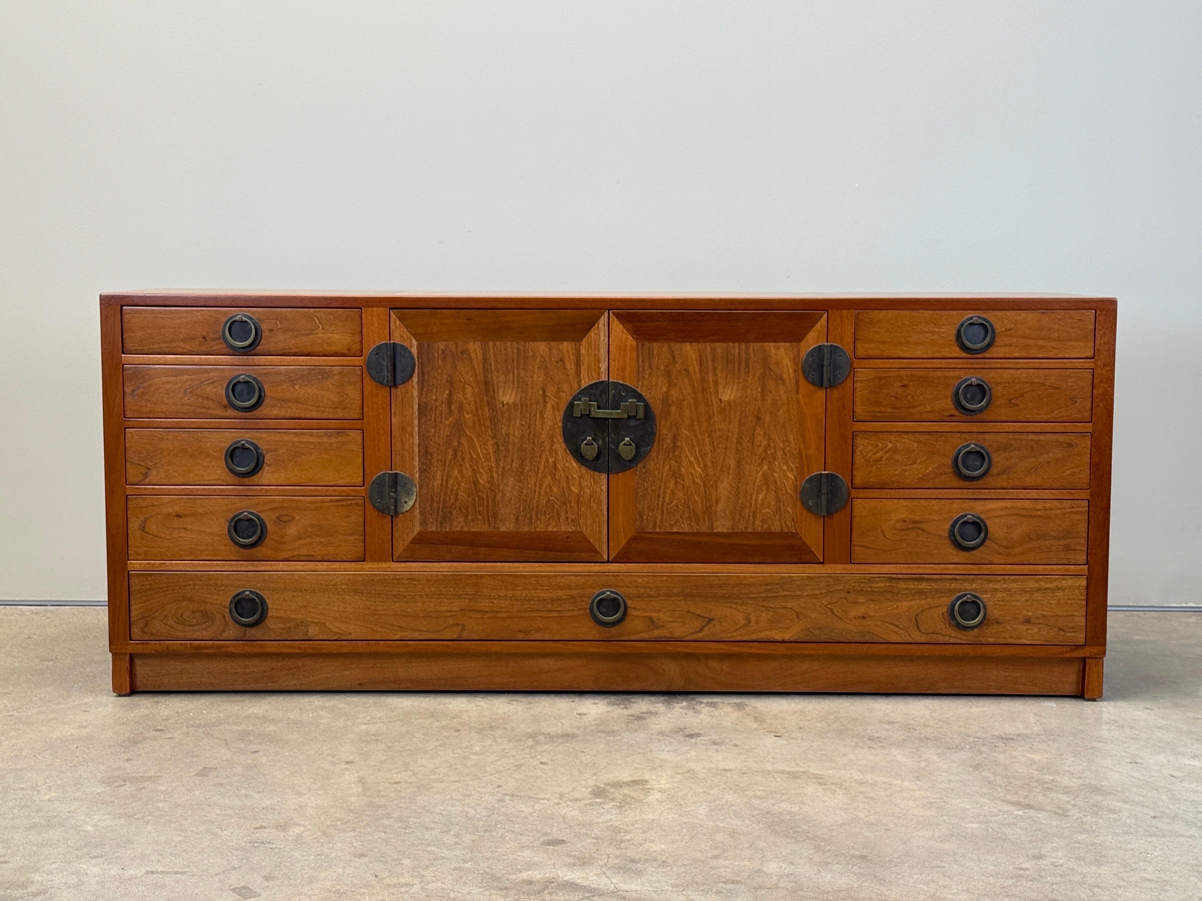 A beautifully restored walnut and mahogany cabinet with brass hardware and pull out trey. Designed by Edward Wormley for Dunbar. 