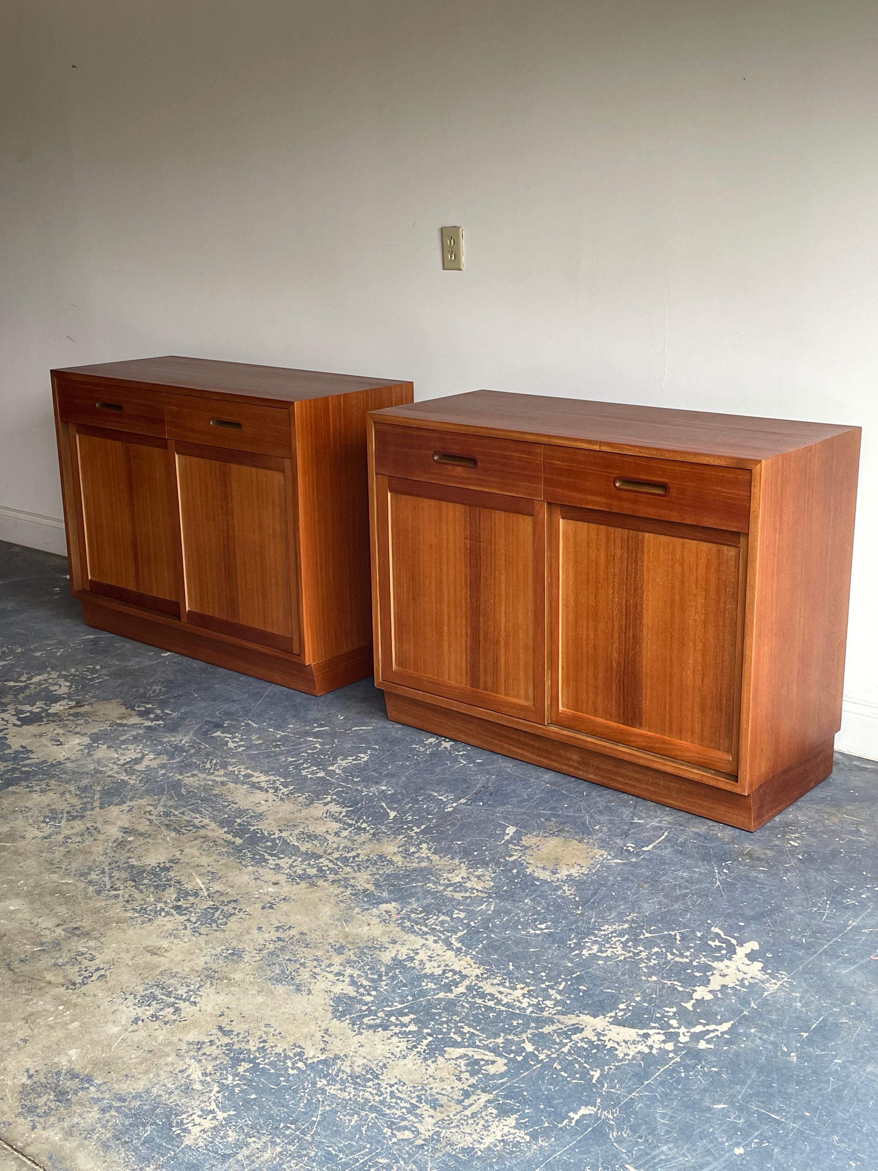 A rare to find pair of cabinets or petite credenzas designed by a Edward Wormley for Dunbar furniture circa 1950s. One cabinet features a total of three shelves in the bottom section which are adjustable height. The other cabinet features three