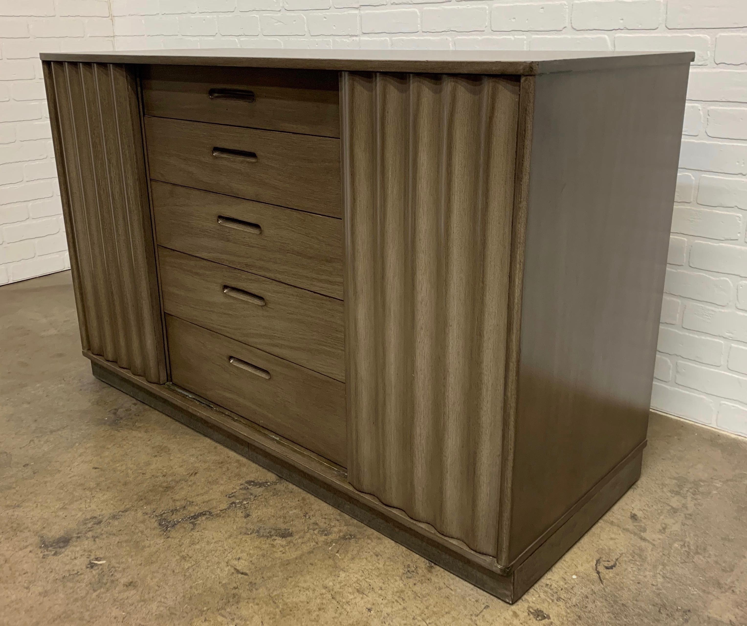 Two Edward Wormley cabinets with corrugated wood sliding doors and center drawer section in a grey brown finish
Each cabinet is 20