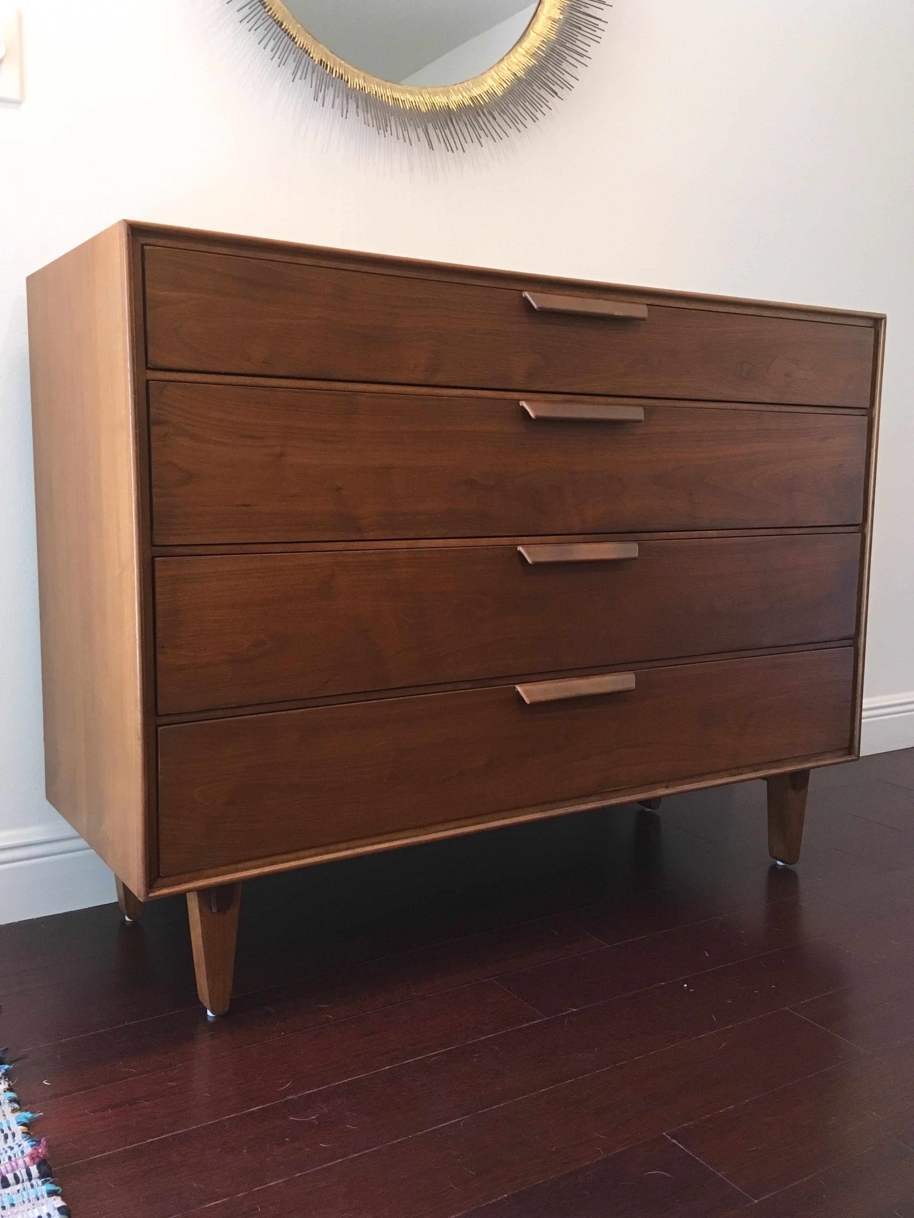 Stunning walnut Dunbar chest designed by Edward Wormley. Four large scale drawers. Legs feature Japanese style- studio/ craftsman details.

 Leather wrapped handles show some signs of wear. Piece has been restored.