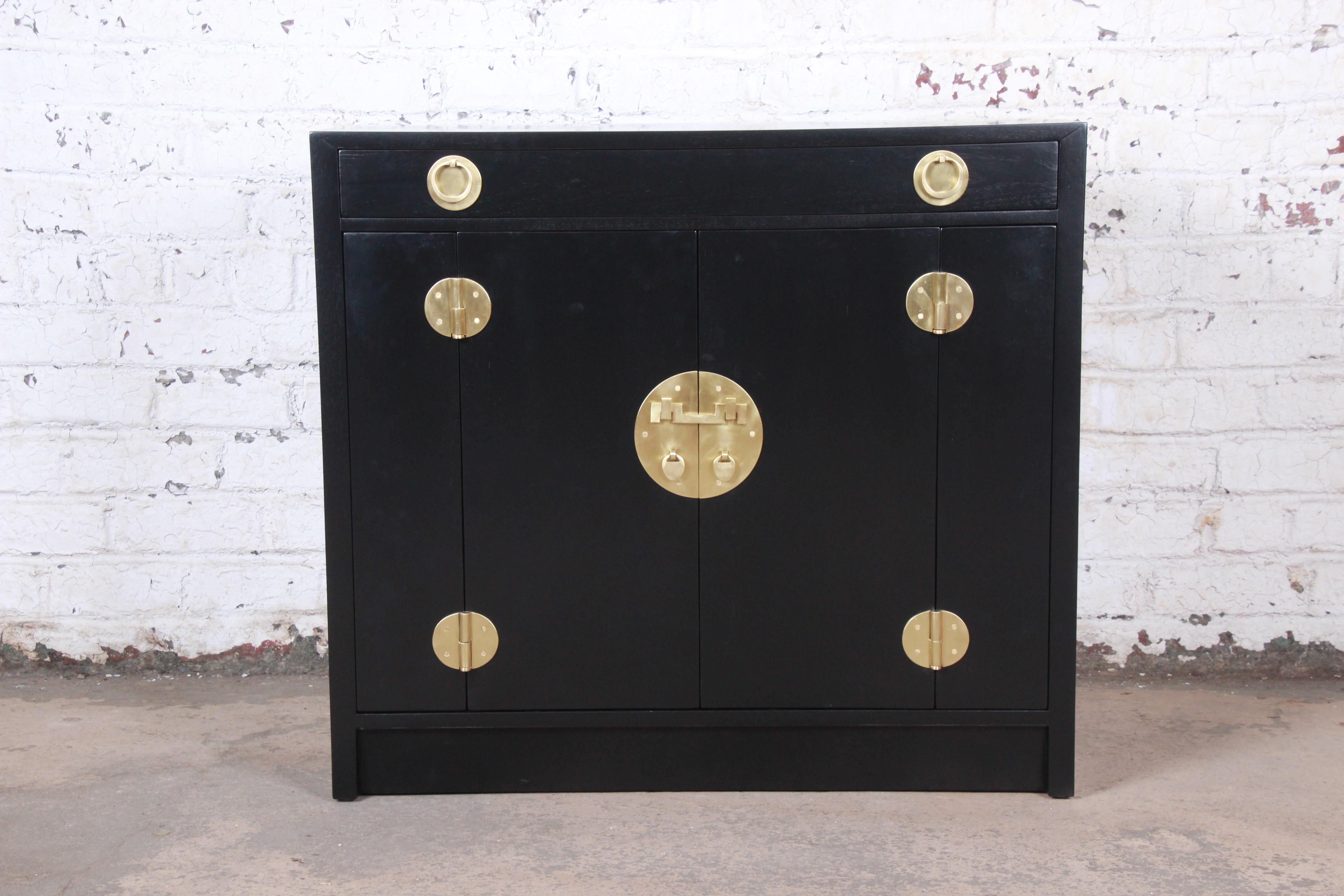 A gorgeous Mid-Century Modern Hollywood Regency Asian-inspired compact credenza, sideboard buffet, or bar cabinet

Designed by Edward Wormley for Dunbar Furniture

USA, 1950s

Newly ebonized walnut and brass hardware

Measures: 38