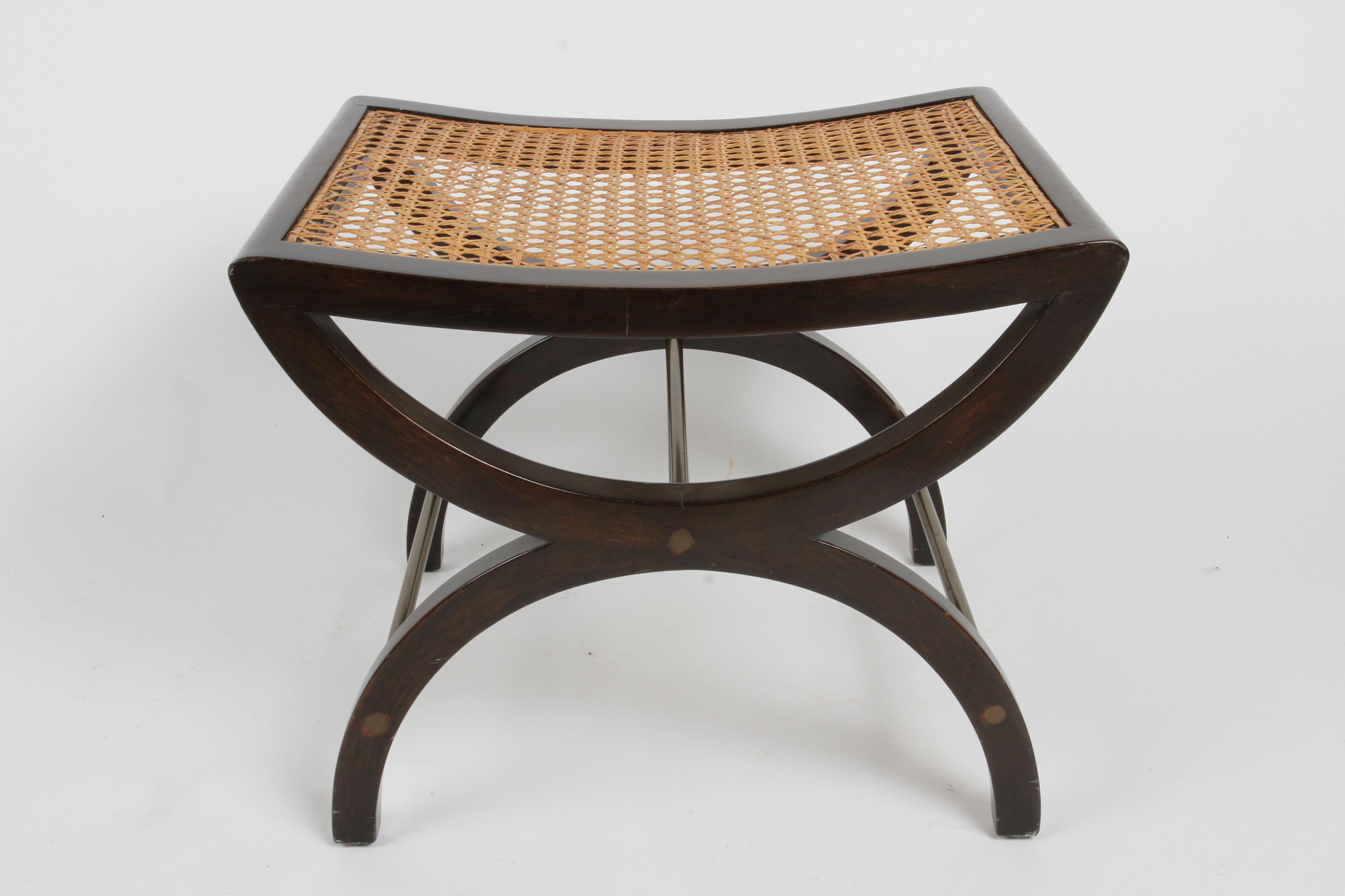 This elegant stool, bench or ottoman was designed by Edward Wormley for the Dunbar Furniture Company in 1950,  model number 5006A. This stool, based on the Ancient Roman Curule seat updated with a MCM aesthetic, has a gently concave seat with