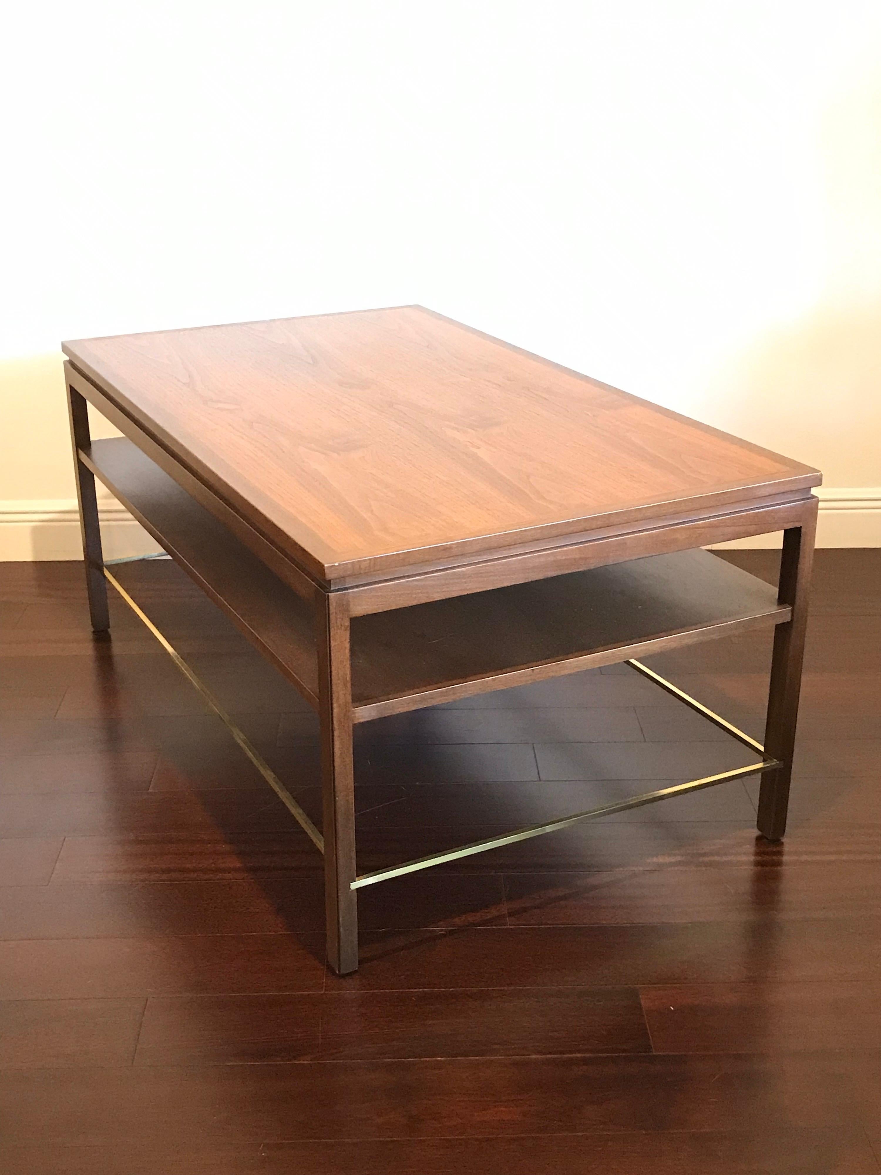 Stunning table by Edward Wormley for Dunbar. Mahogany band on top and mahogany legs, walnut top, and brass stretchers all around. Excellent vintage condition with minimal signs of wear. Truly time capsule condition.

Use as a coffee table,