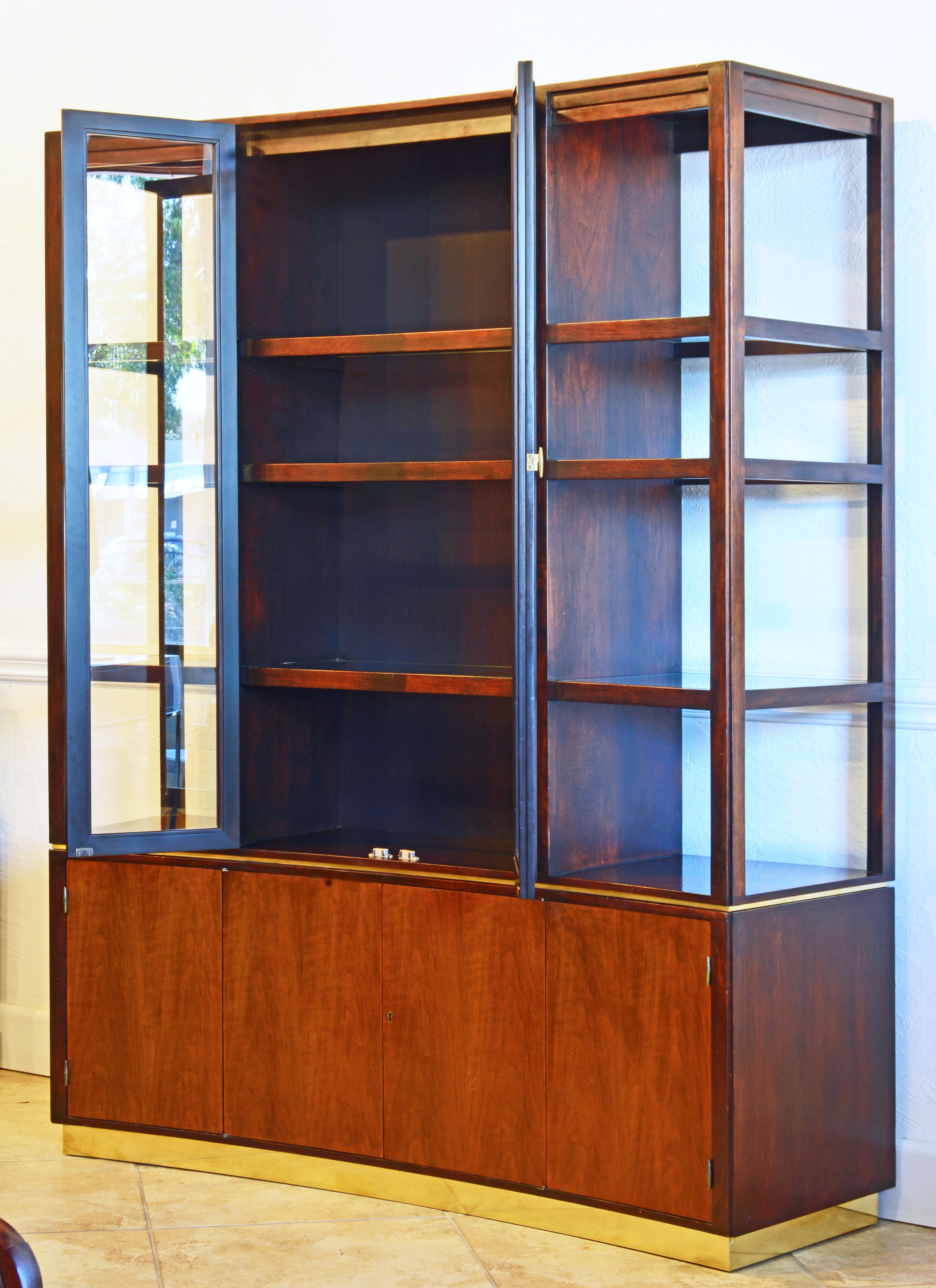 This superior design by Edward Wormley combines the sideboard or credenza with open and closed glass shelving in a curve front wall unit often called the Superstructure. It is made of walnut in two tones, the cabinet doors being the lighter one. The