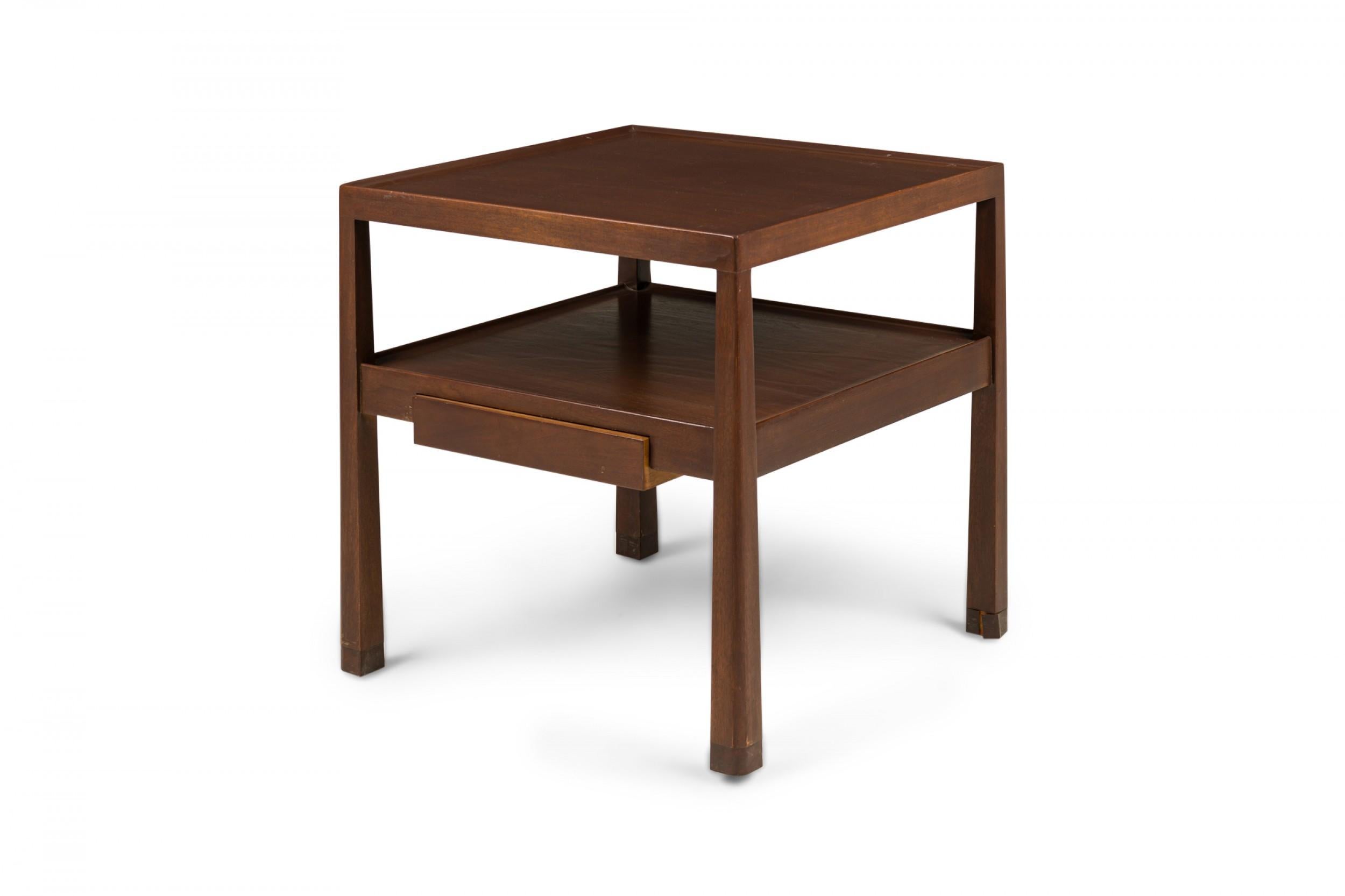 Table d'appoint / d'appoint à deux niveaux en bois fini foncé du milieu du siècle dernier, à plateau carré avec une galerie peu profonde au-dessus d'une étagère inférieure contenant un seul tiroir, soutenue par deux pieds fuselés inversés. (EDWARD