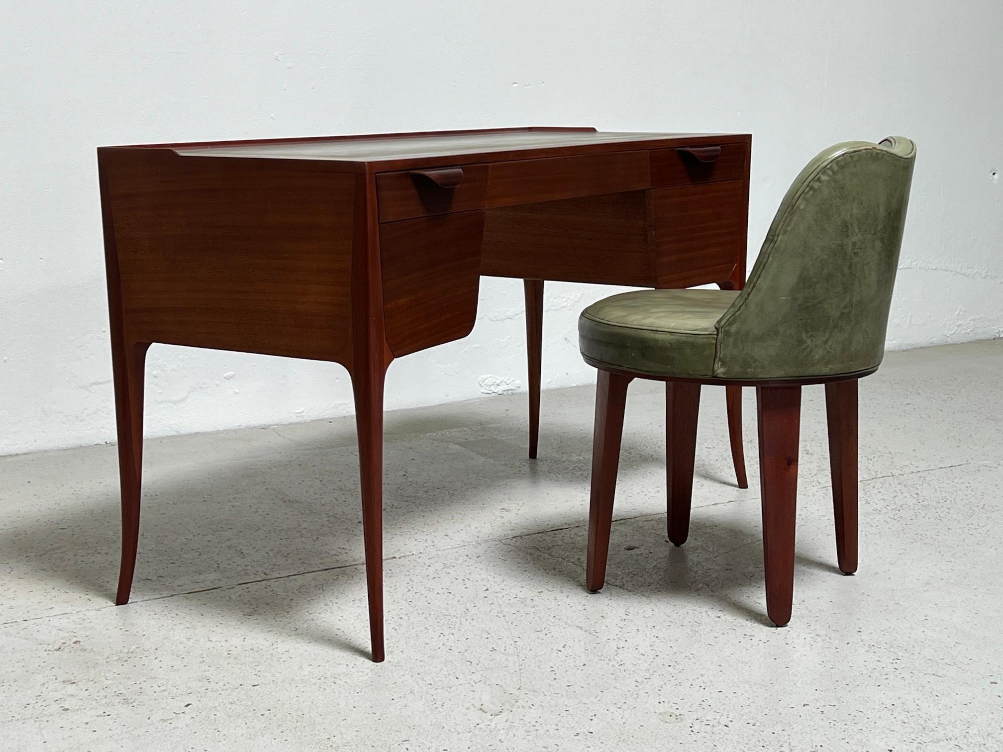 An elegant and early design by Edward Wormley for Dunbar. Desk model 4725 in mahogany with original green leather and matching swiveling stool.