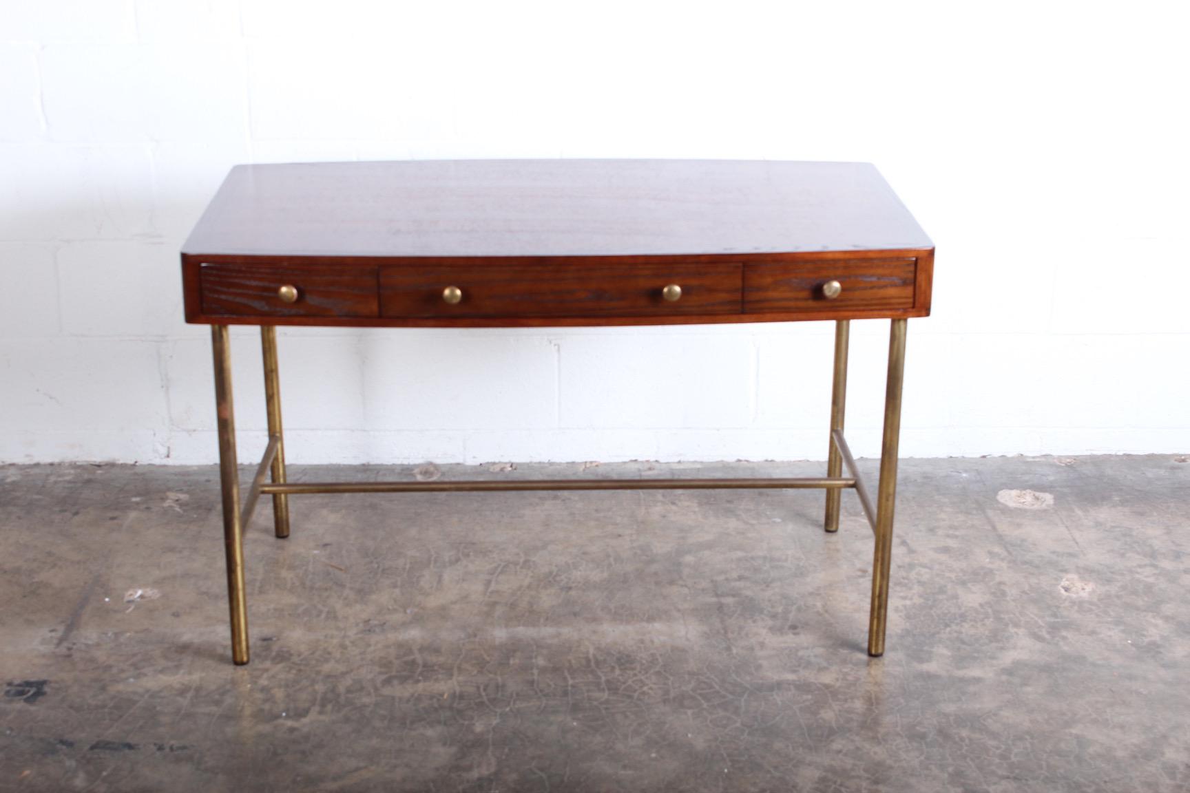 An oak and ash desk with brass base and hardware. Designed by Edward Wormley for Dunbar.