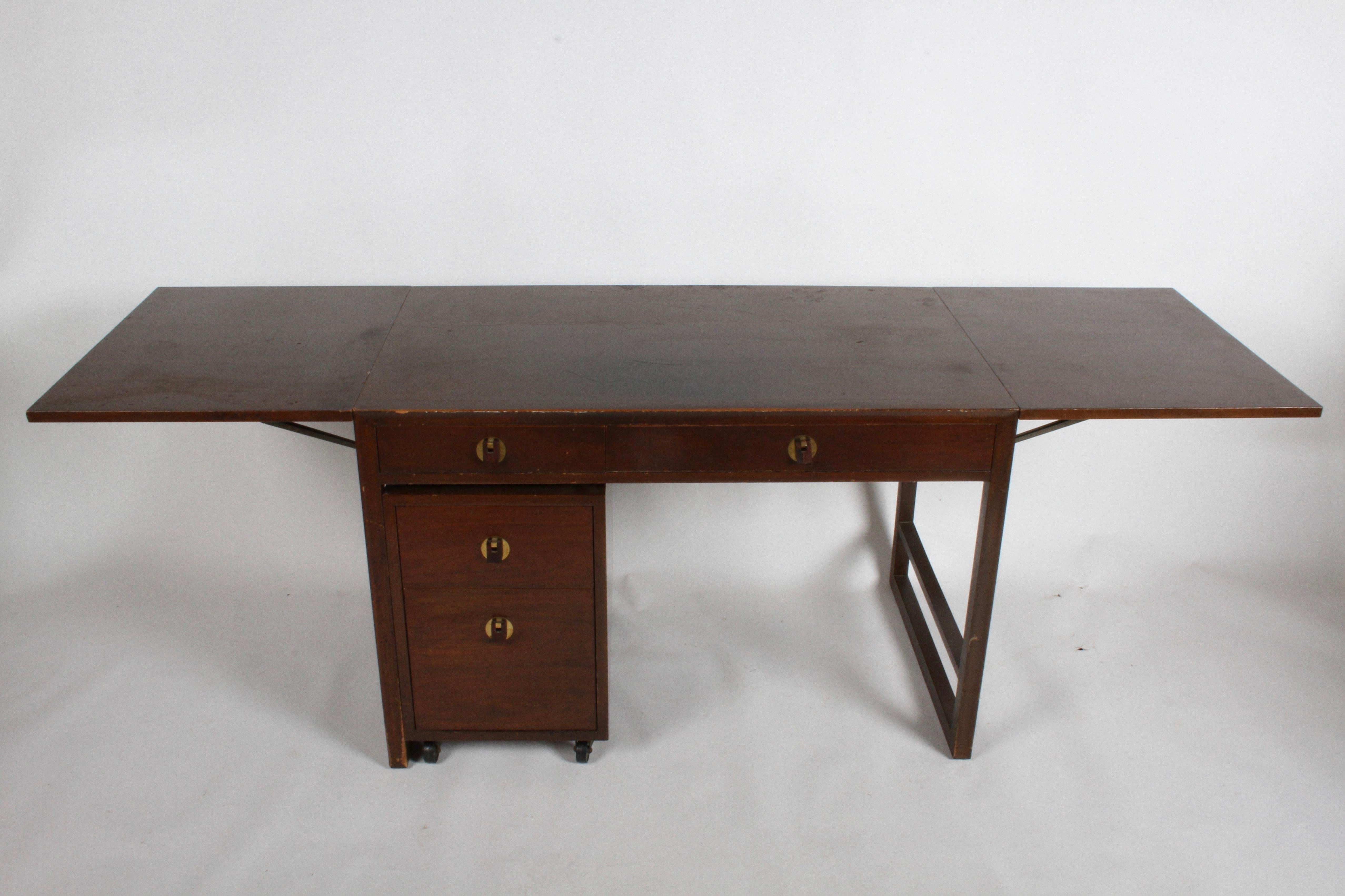 Uncommon Mid-Century Modern Edward Wormley model no.301-A designed compact desk for Dunbar, with two drop leaf extensions and model no.302-A pedestal file cabinet on wheels. Desk has two drawers, one large & medium includes pencil holder, with brass