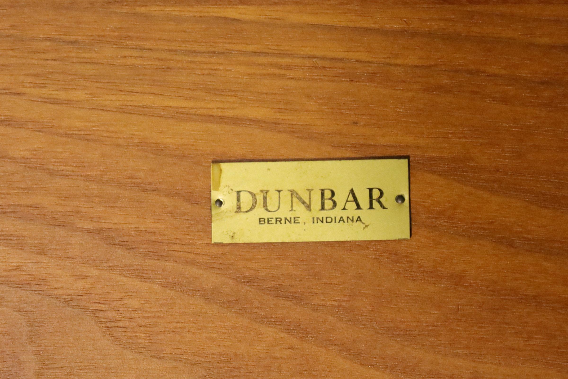 Great looking side table in a hexagonal shape with a circular top. Table opens to reveal a shelf and a compartment to store bottles on the side of the door. Table has original Dunbar key and label. 