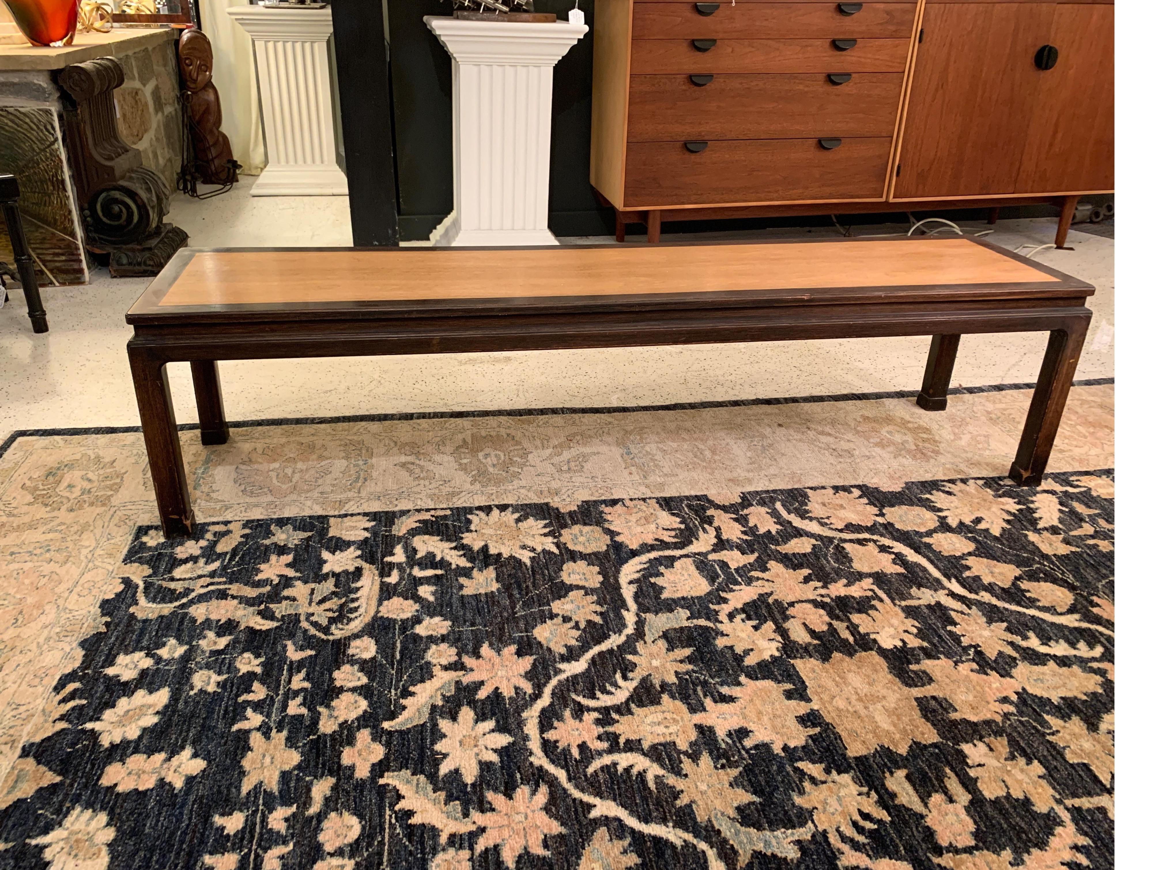 Classic and impressive long coffee table or bench in an Asian motif in walnut, designed by Edward Wormley for Dunbar, early 1950s. Retains early green label. Original distressed two-tone finish, with some age appropriate nicks and scuffs - in