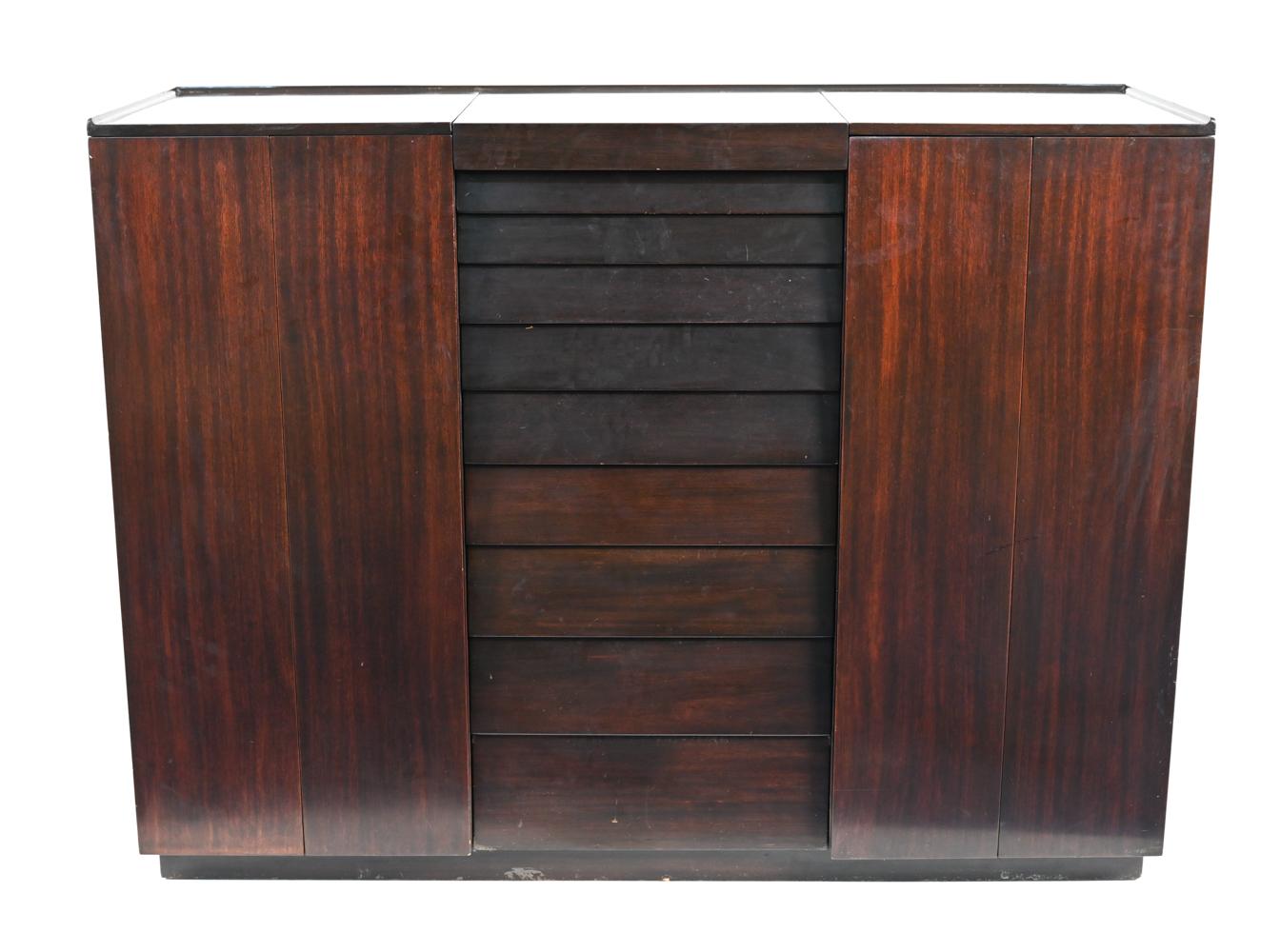 Une belle armoire fonctionnelle conçue par Edward Wormley pour Dunbar, vers le milieu des années 1950. Cette pièce en acajou ébonisé comporte des portes d'armoire pliantes, qui s'ouvrent pour révéler un intérieur aménagé, des tiroirs centraux à