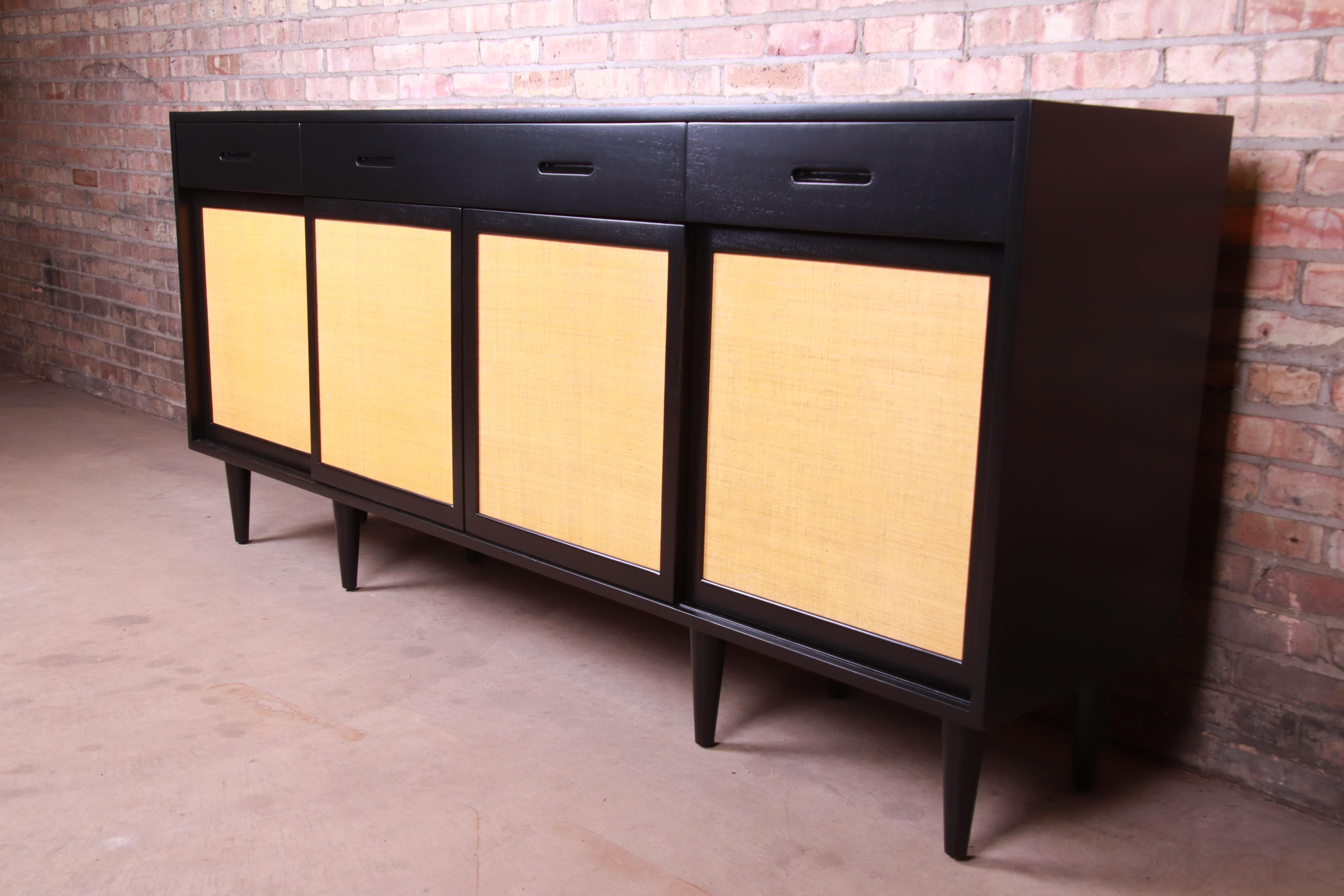 An exceptional Mid-Century Modern sideboard credenza or bar cabinet

By Edward Wormley for Dunbar Furniture

USA, 1950s

Ebonized walnut, with sliding grass cloth doors.

Measures: 81.5