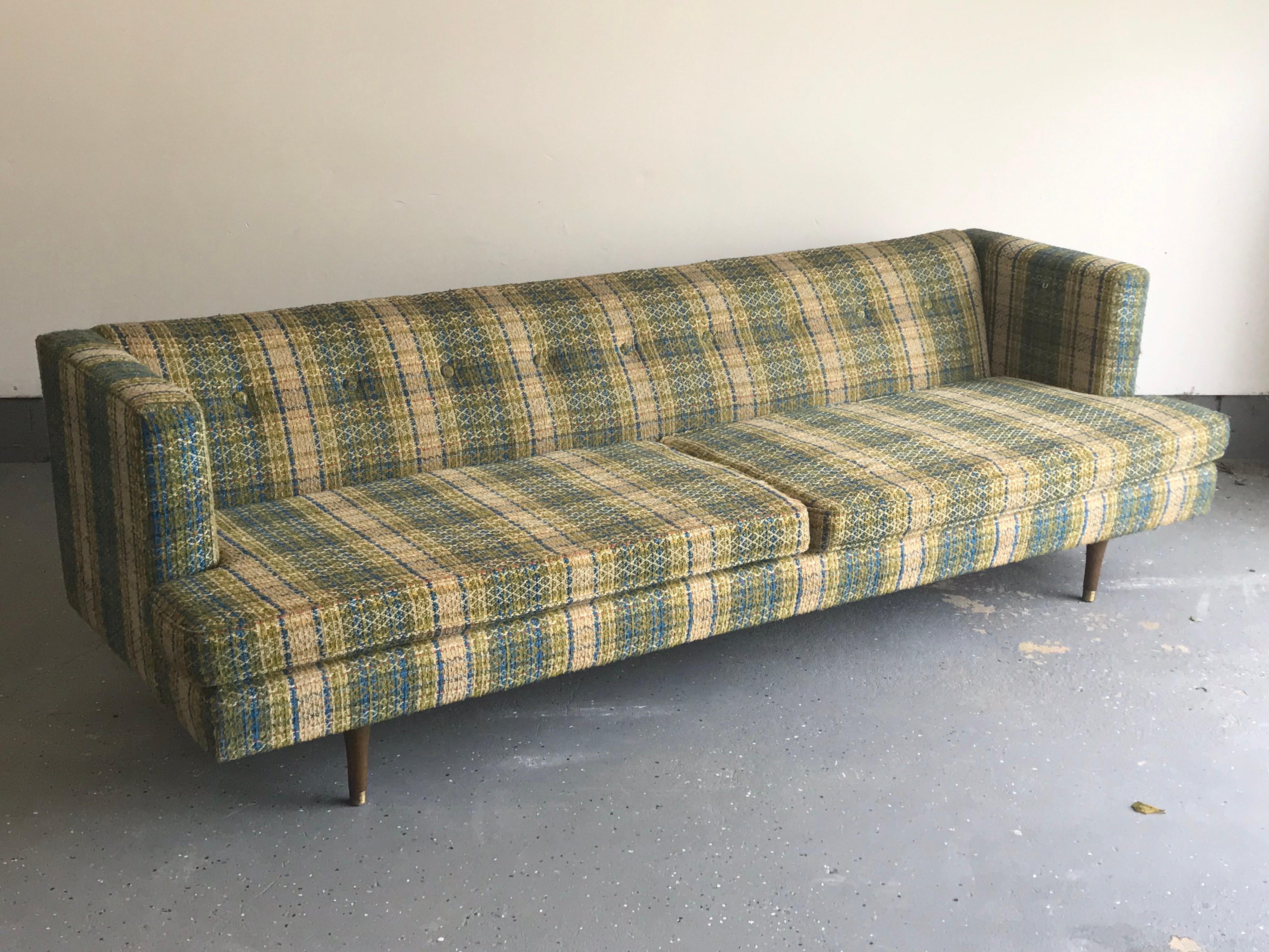 Iconic sofa designed by Edward Wormley for Dunbar. Features even height arms, button back, and brass capped tapered mahogany legs. Extremely well built sofa. Sofa was reupholstered into the 1960s.

Upholstery is relatively clean for the age,