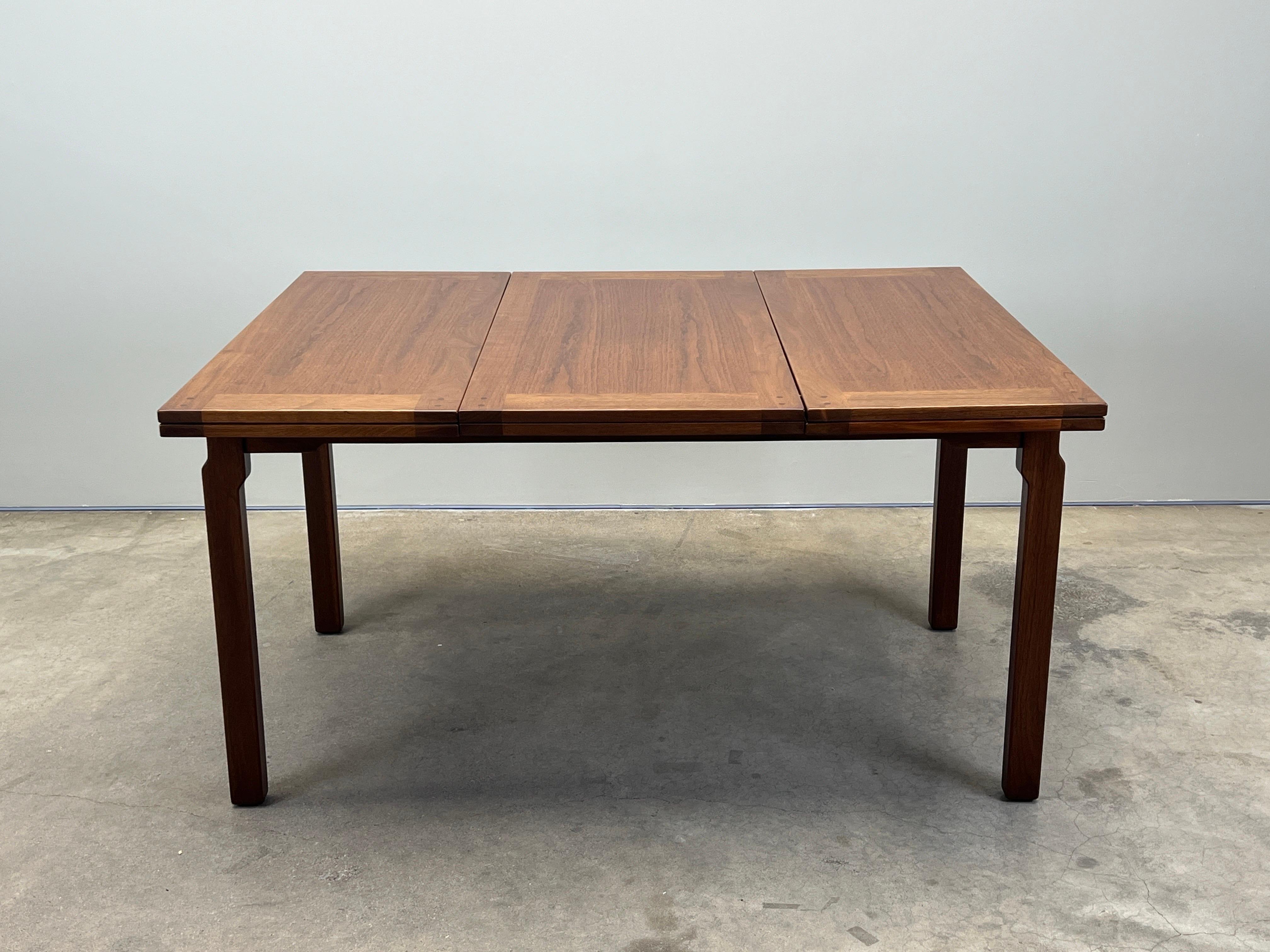 Rare table de salle à manger extensible conçue par Edward Wormley pour Dunbar. Connue sous le nom de table Greene & Greene pour son aspect artisanal et ses tenons apparents. La table se replie aux extrémités et le battant central se déplace de haut