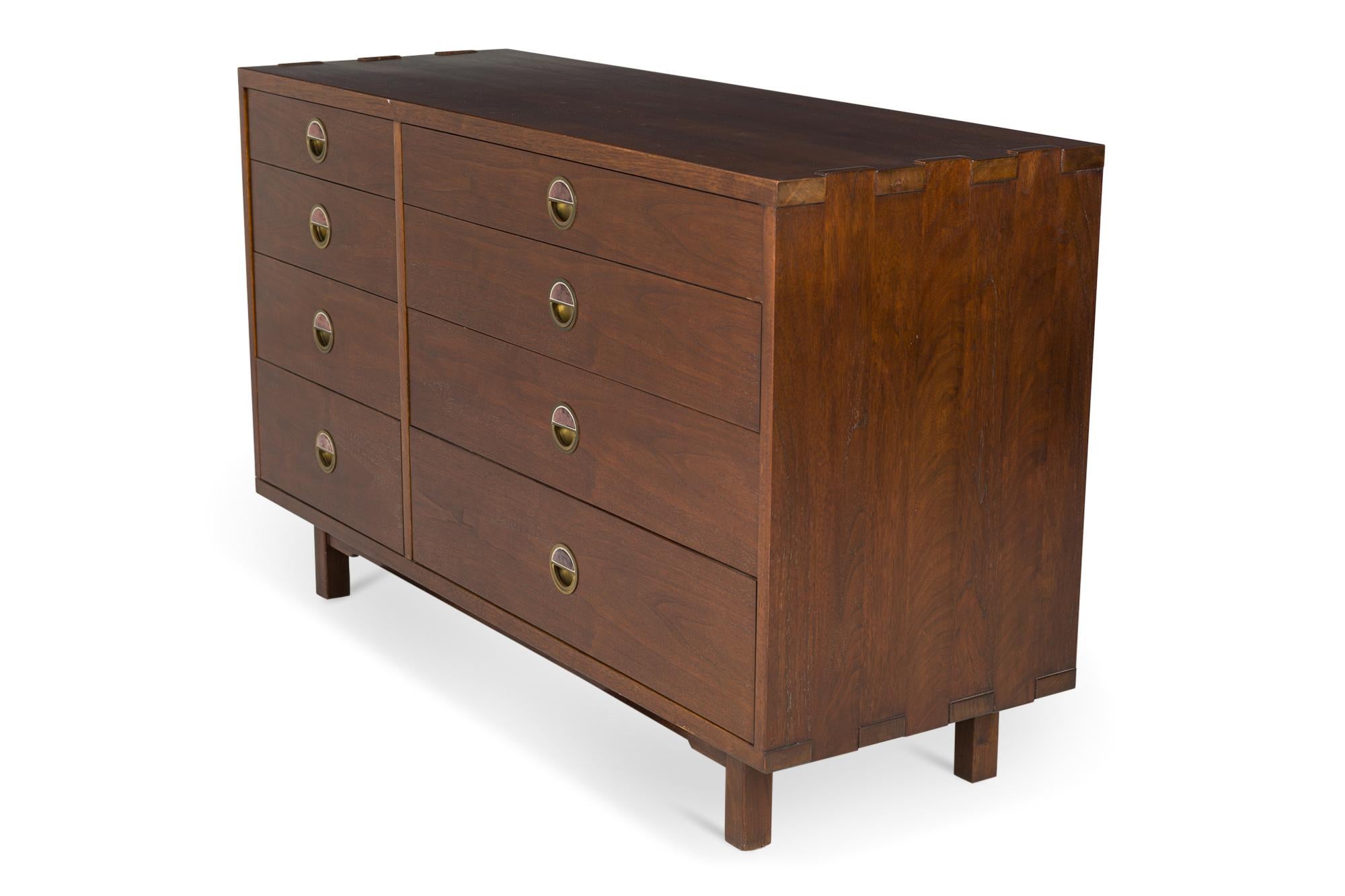 American mid-century walnut eight-drawer chest comprised of a narrow set of drawers on the left and a wider set of drawers on the right , all with drawer pulls made of brass and Natzler ceramic half-moon burgundy tiles, resting on four square walnut