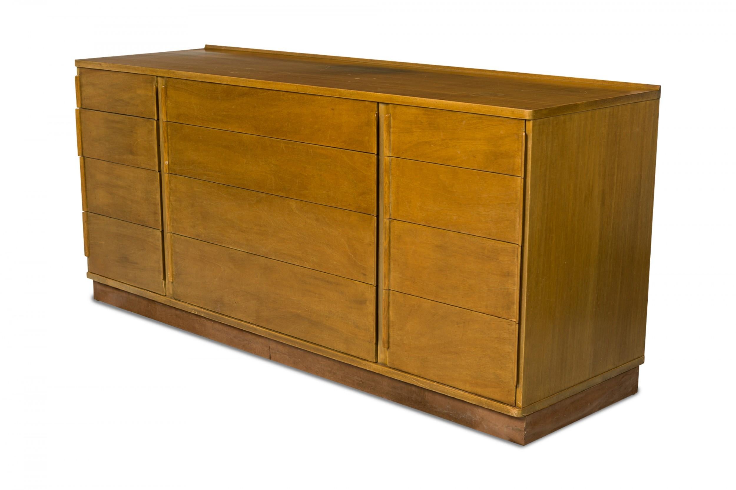 American mid-century walnut low chest of drawers with three sets of four drawers, one set wider and central, flanked on either side by two narrower sets of drawers. (EDWARD WORMLEY FOR DUNBAR FURNITURE CO.)