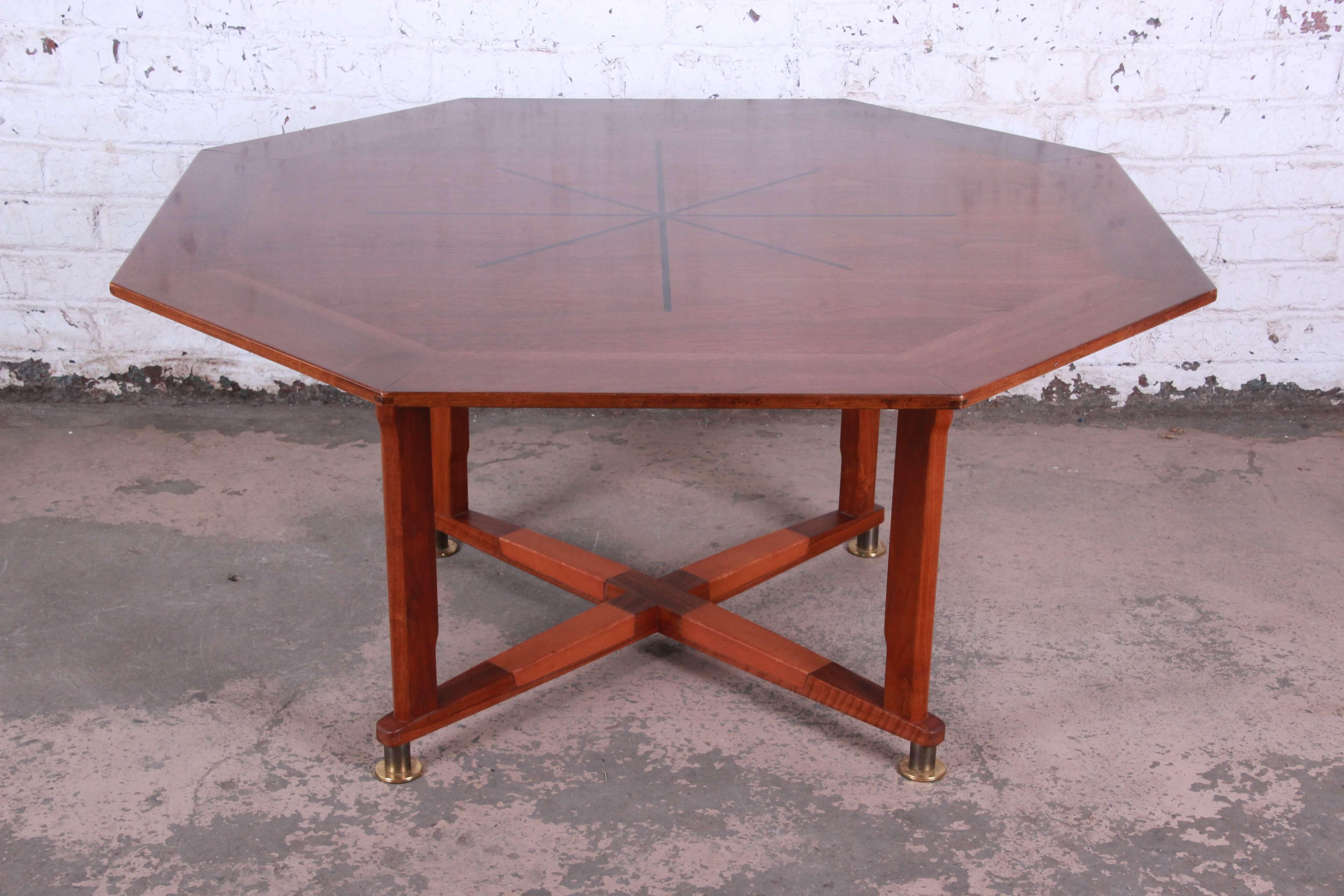 Offering an excellent Edward Wormley for Dunbar Janus collection game table or lower dining table. This octagonal table features an inlaid rosewood starburst with beautiful walnut wood grain and exposed tenon joinery. The base sits on brass feet